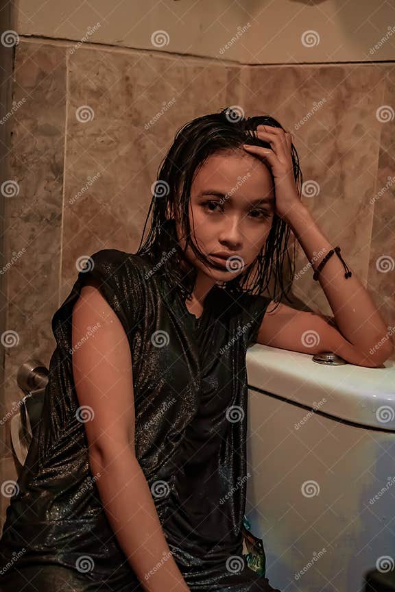 Hot And Wet Asian Girl Poses With Sensual Style While Wearing Black Wet Dresses Stock Image