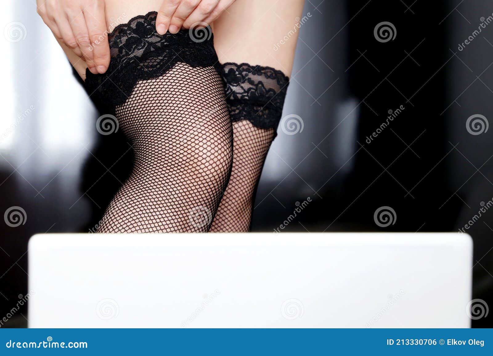 Hot Woman in Black Fishnet Stockings Posing in Front of Laptop Webcam Stock Photo