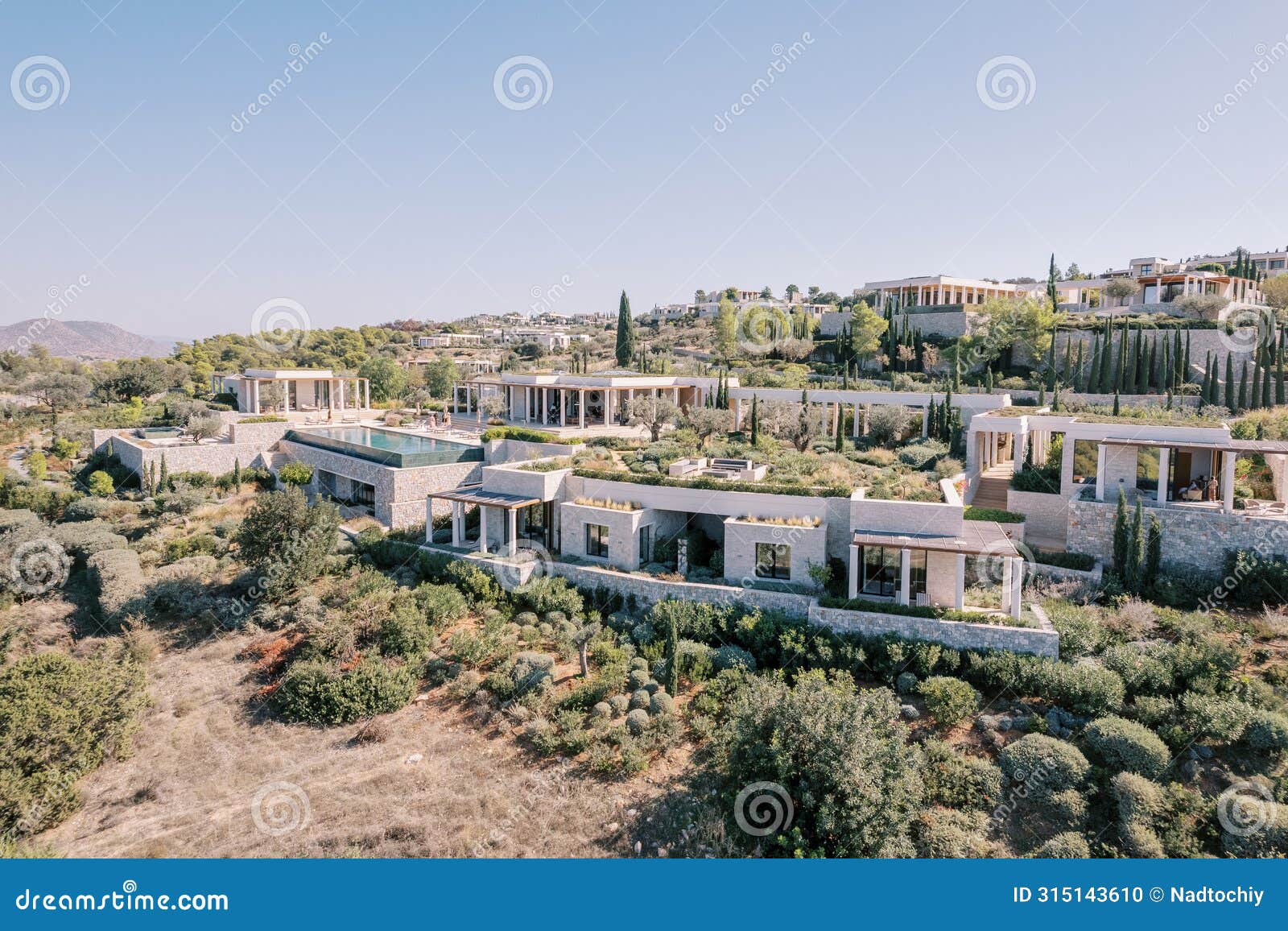 hotel complex with colonnades on a hill. amanzoe, peloponnese, greece. drone