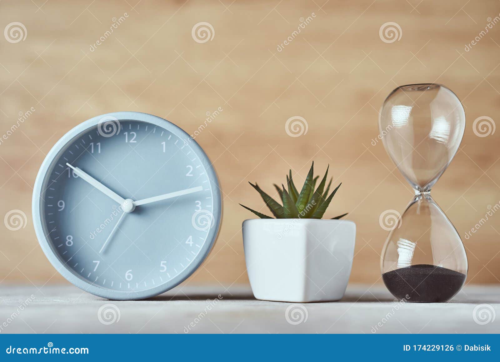 Hourglass, Alarm Clock and Plant on the Table, Close Up Stock Photo