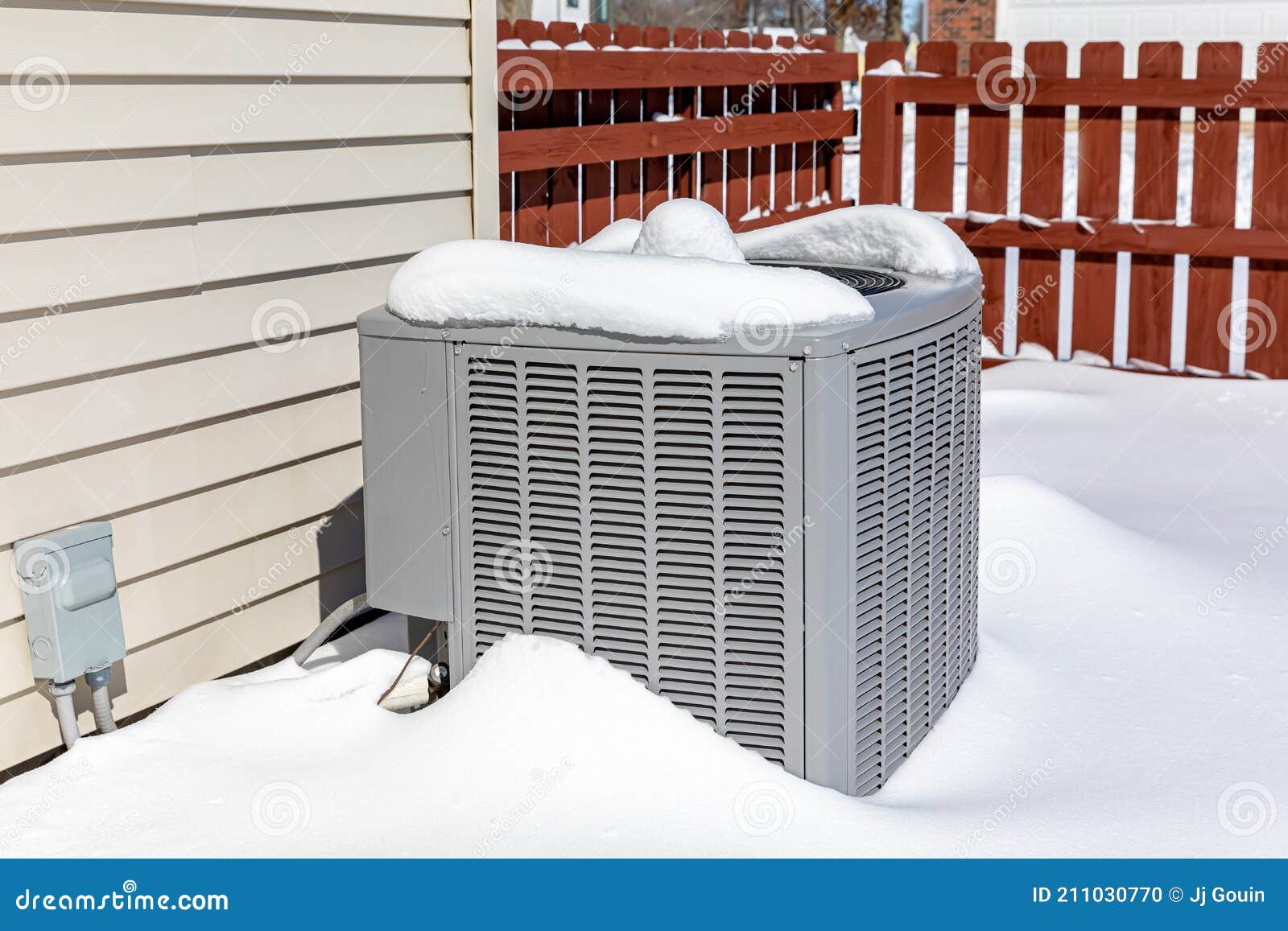 house air conditioning unit covered in snow during winter