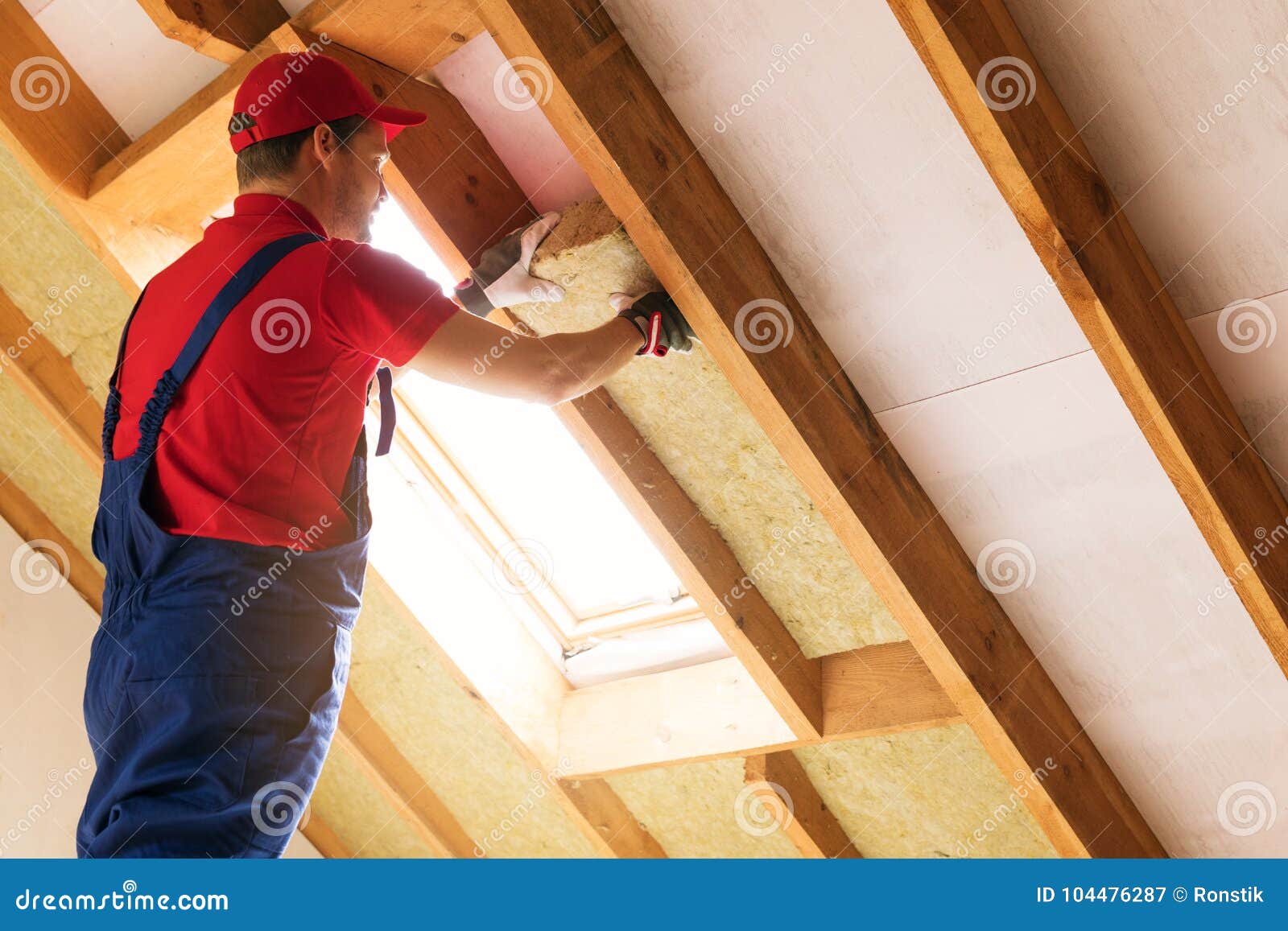 house attic insulation - construction worker installing wool