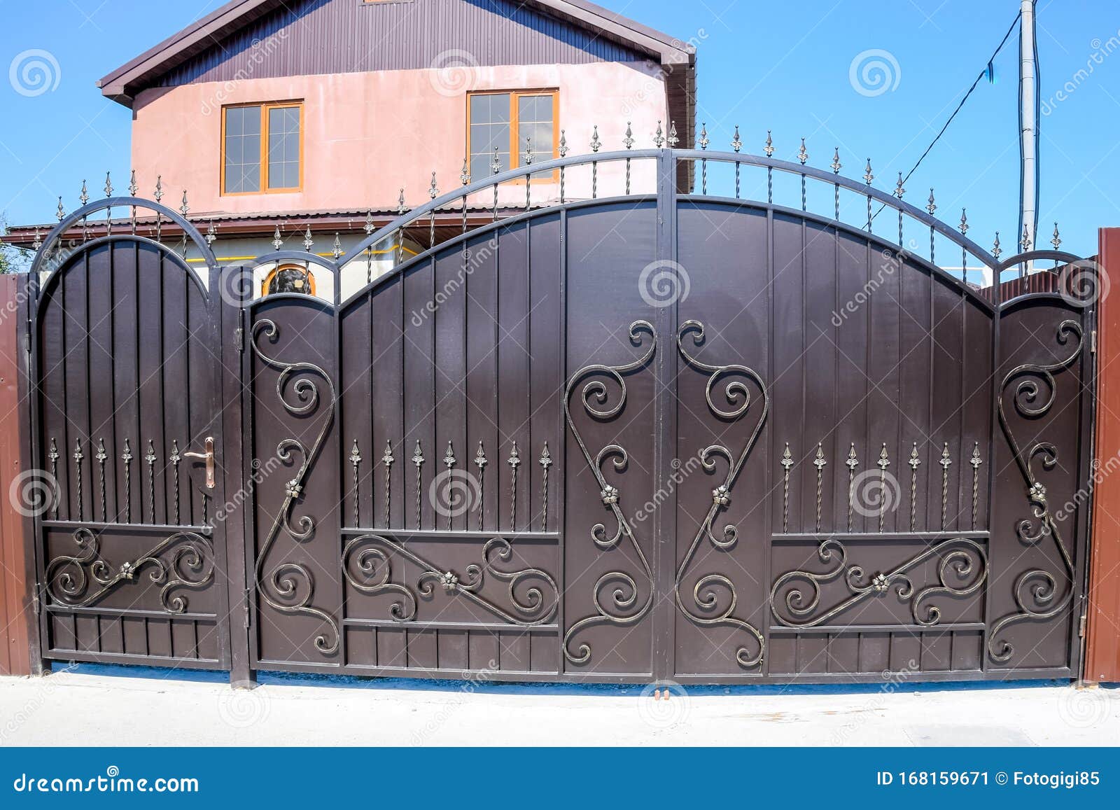 House with a Fence and Gates. View of a New Fence and a House Stock