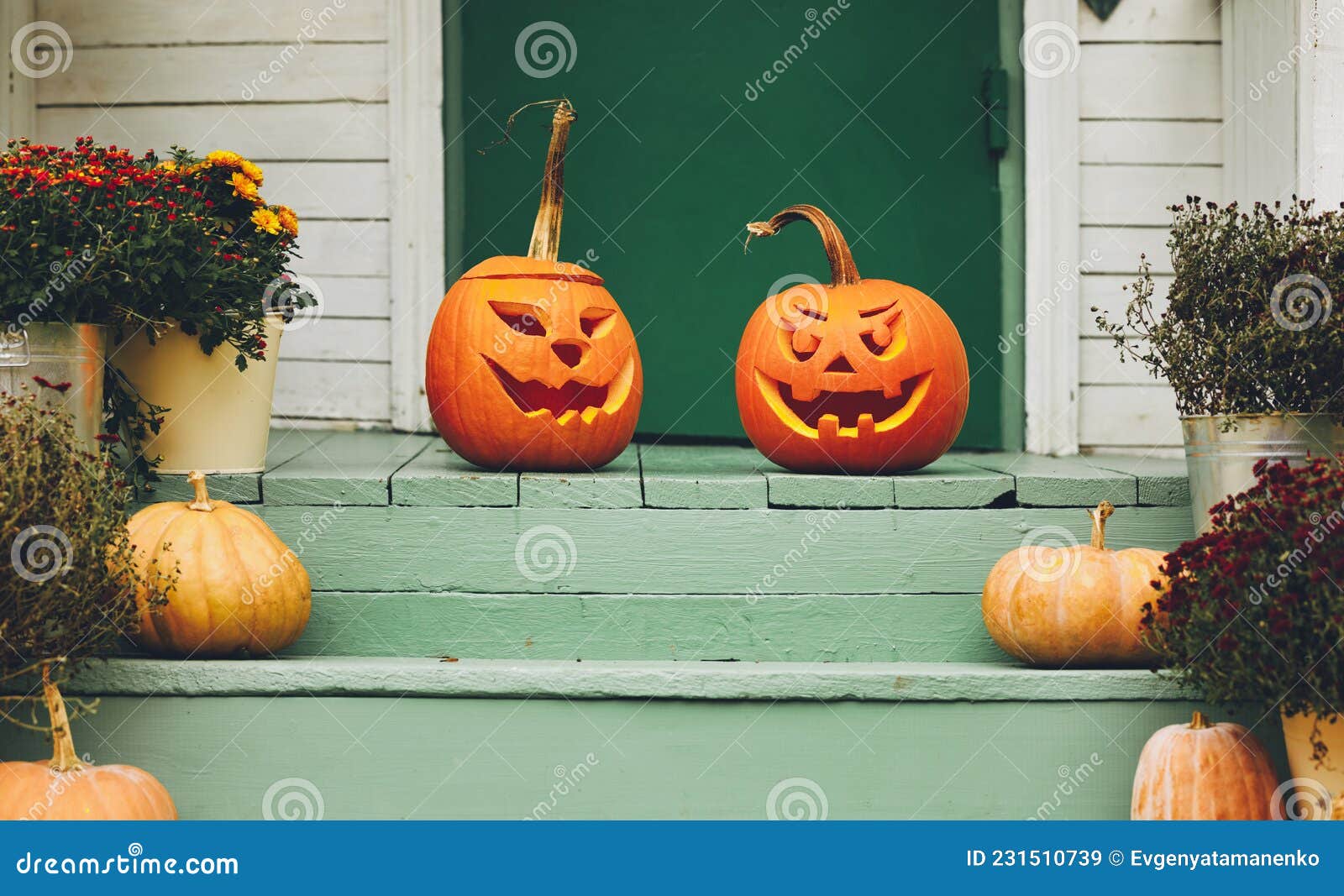 house with halloween orange pumpkin decoration, jack o lanterns with spooky faces on porch