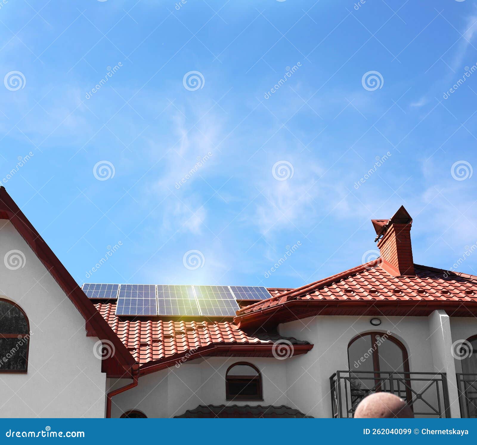 House with Installed Solar Panels on Roof Under Blue Sky. Alternative