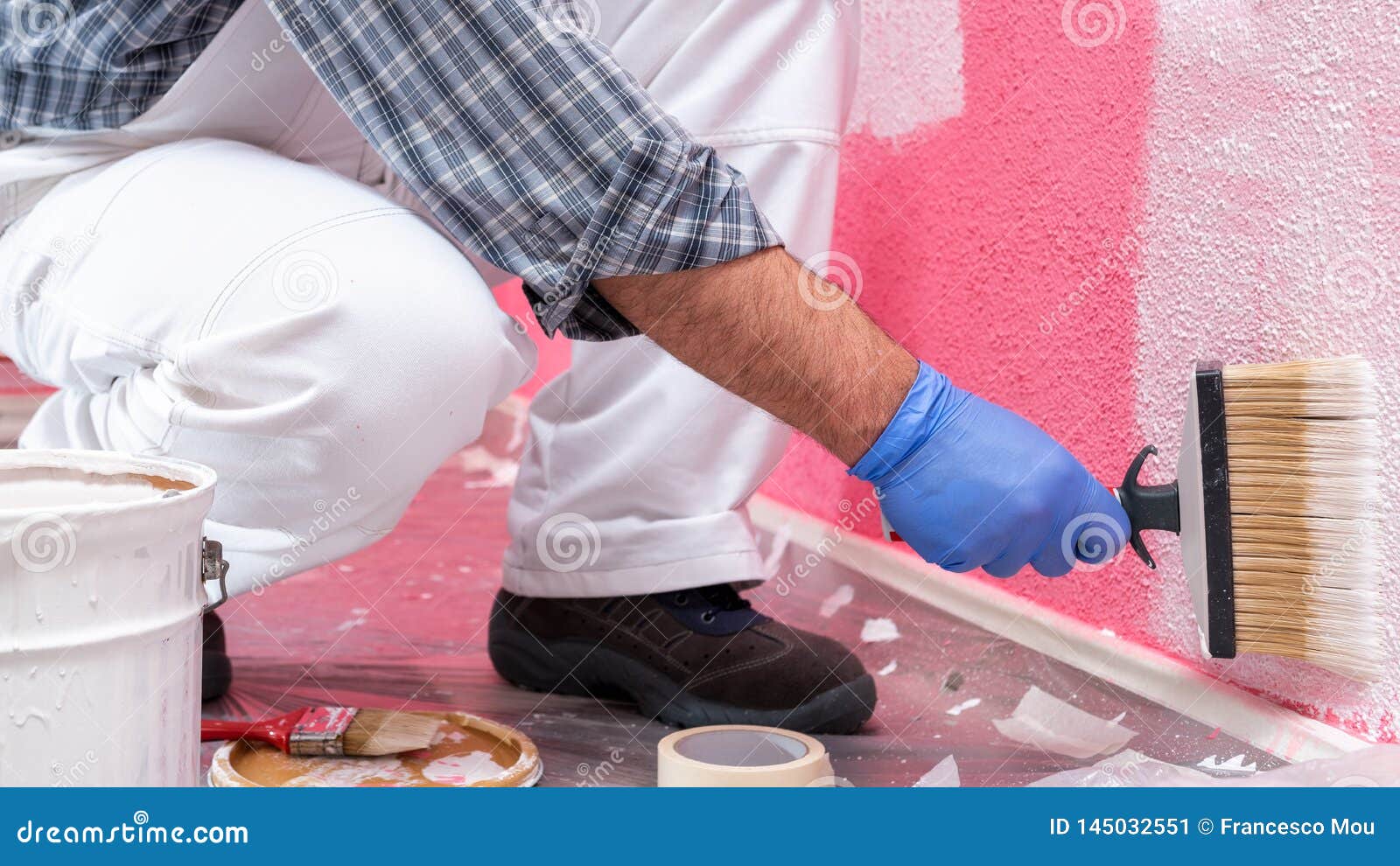 House Painter Worker at Work in the Construction Site. Building Stock