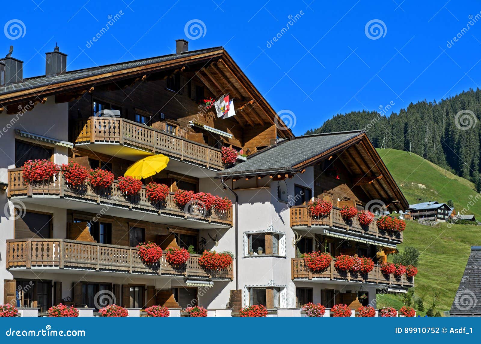 house with red geraniums on the balconies