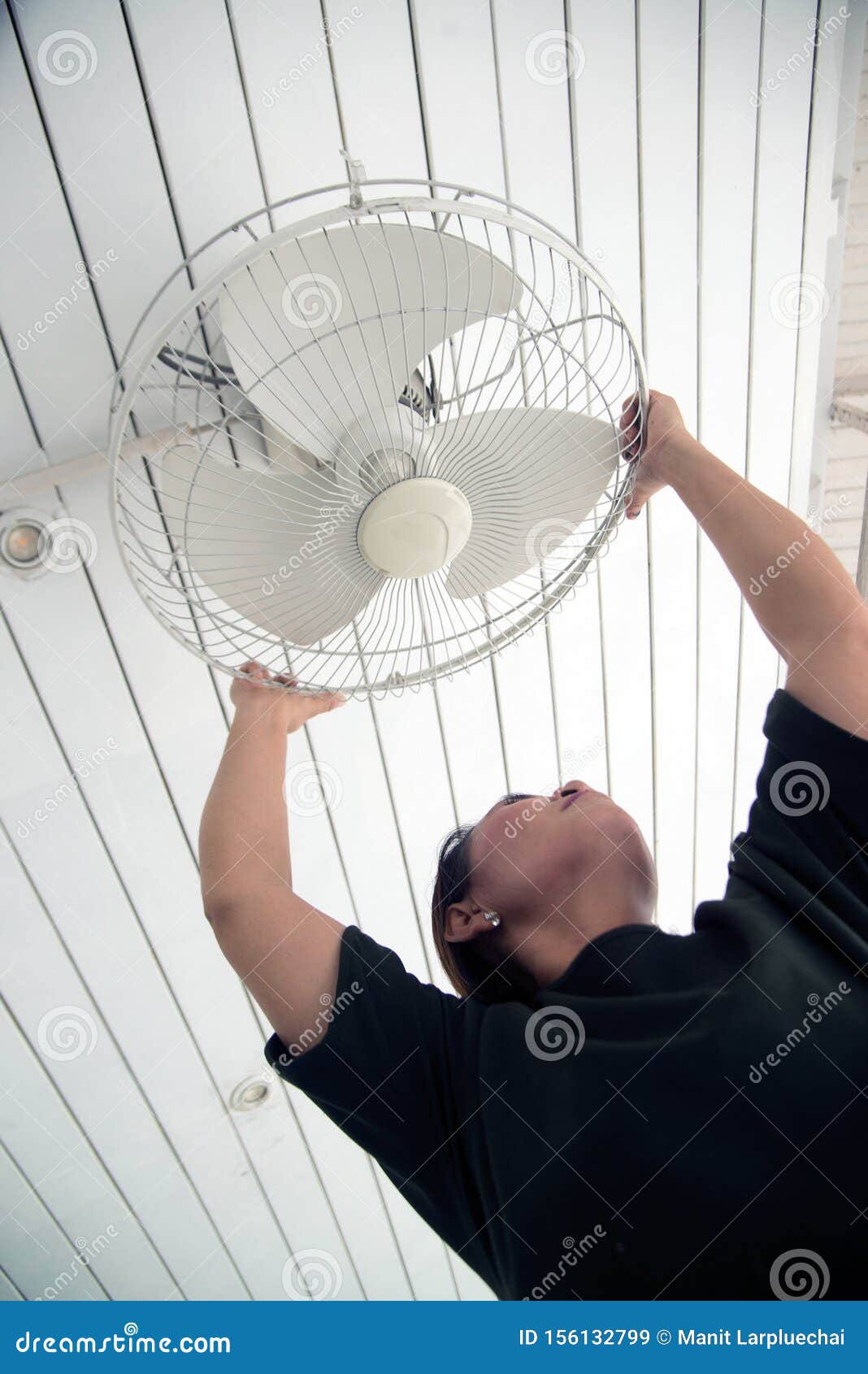The Maidservant Is Installing And Cleaning The Ceiling Fan