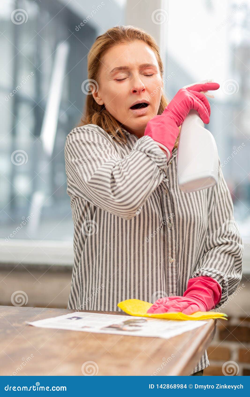 Housewife Cleaning Kitchen Sneezing after Using Chemicals Stock Photo