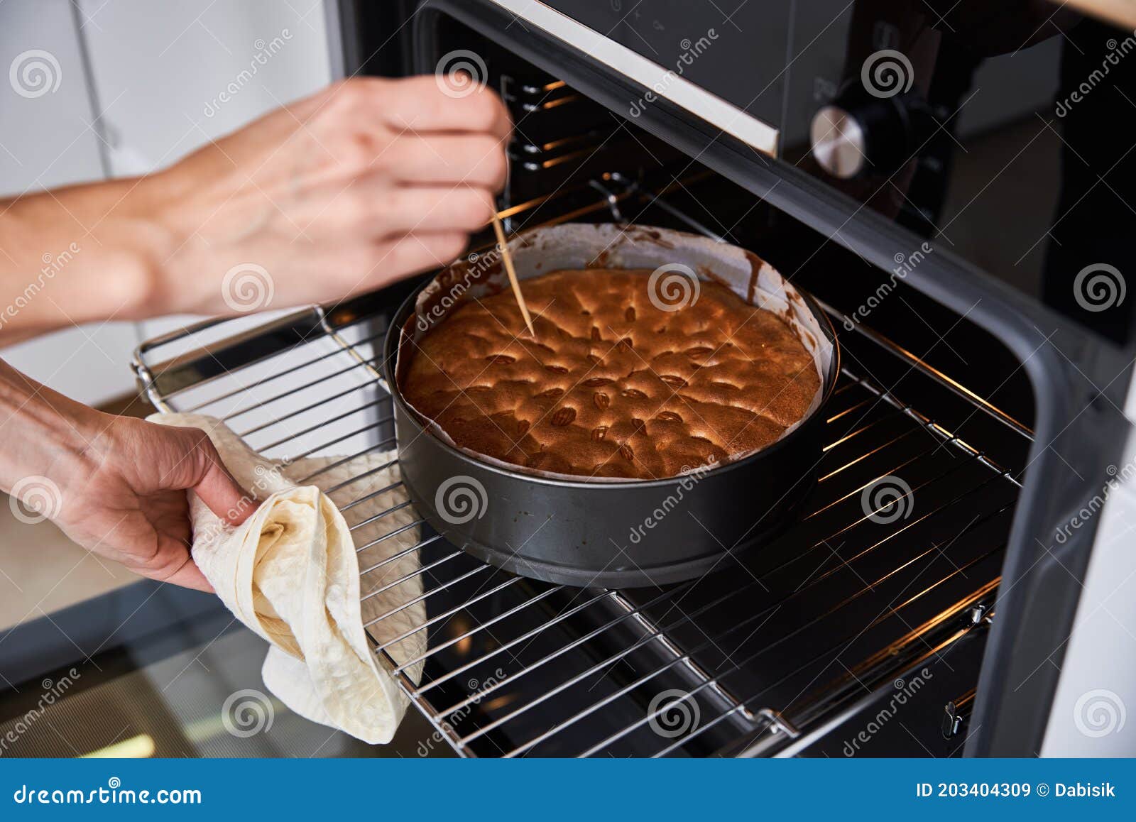 Female hand turning on the oven to make a cake at home. Close-up of the