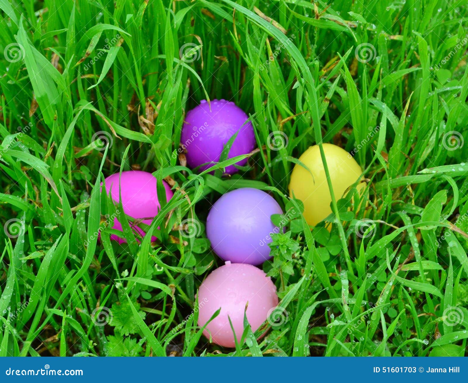 Huevos de Pascua. El amarillo, rosado y la púrpura colorearon el huevo de Pascua plástico en hierba verde