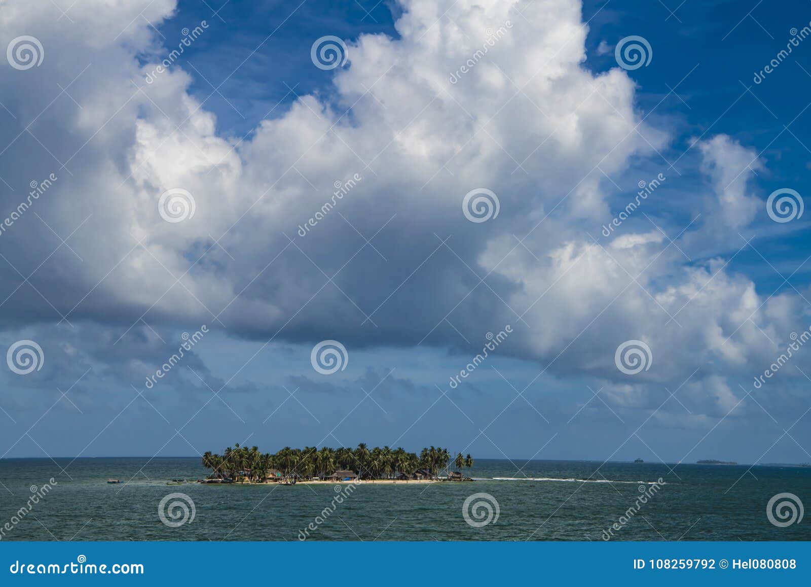 huge clouds over small island in caribbean sea