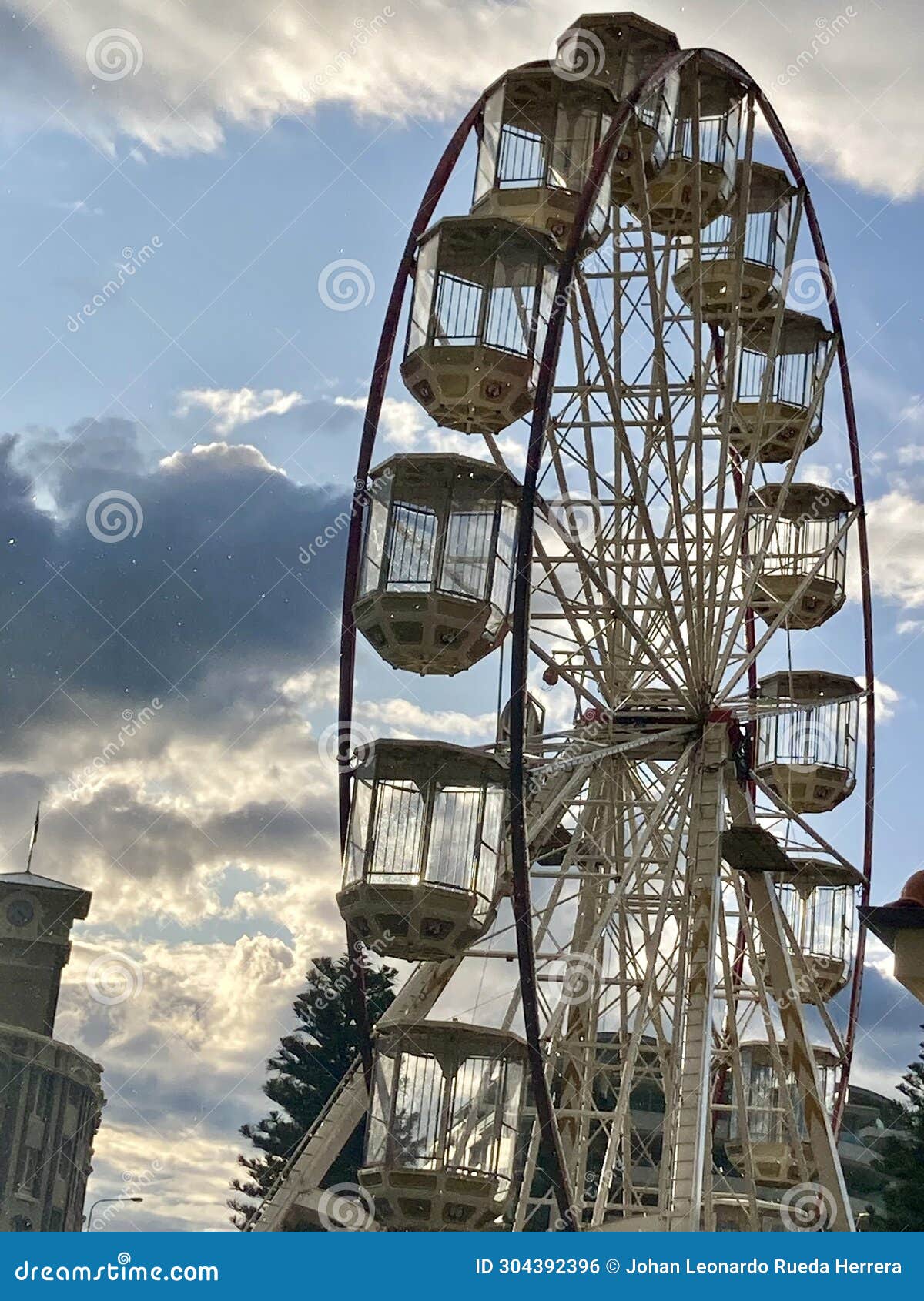 huge ferris wheel, on a sunny day with blue sky and clouds