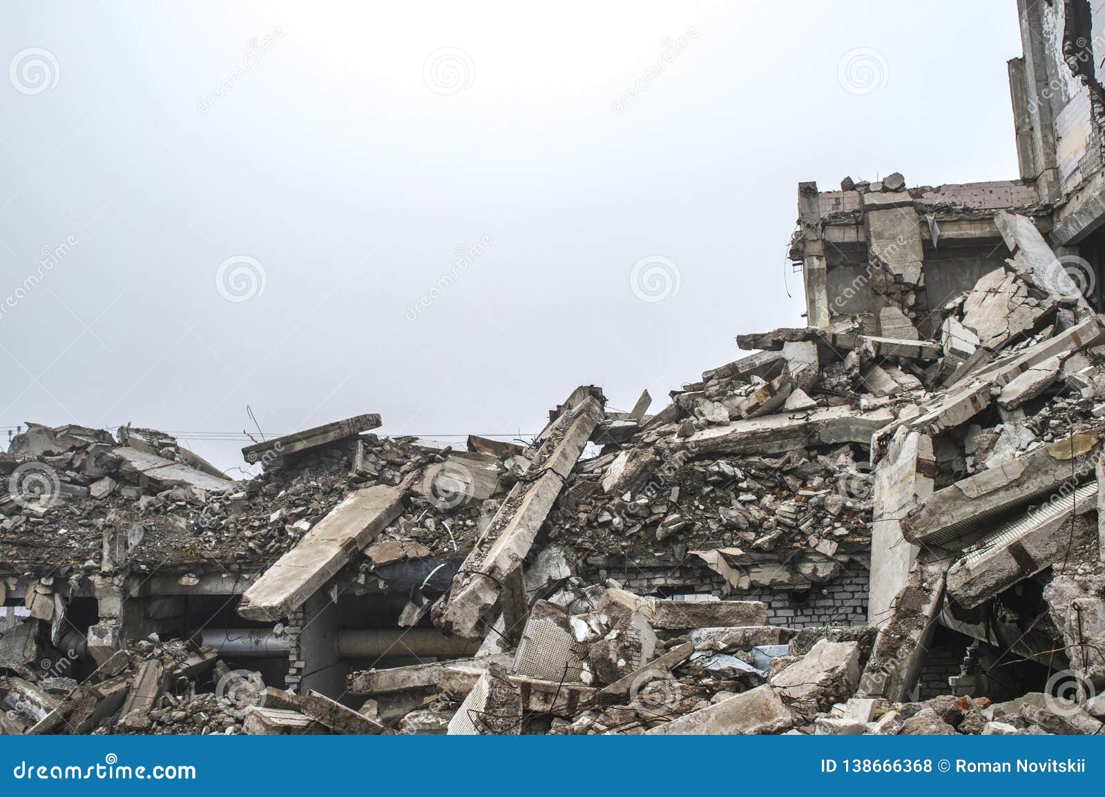 a huge pile of gray concrete debris from piles and stones of the destroyed building. the impact of the destruction