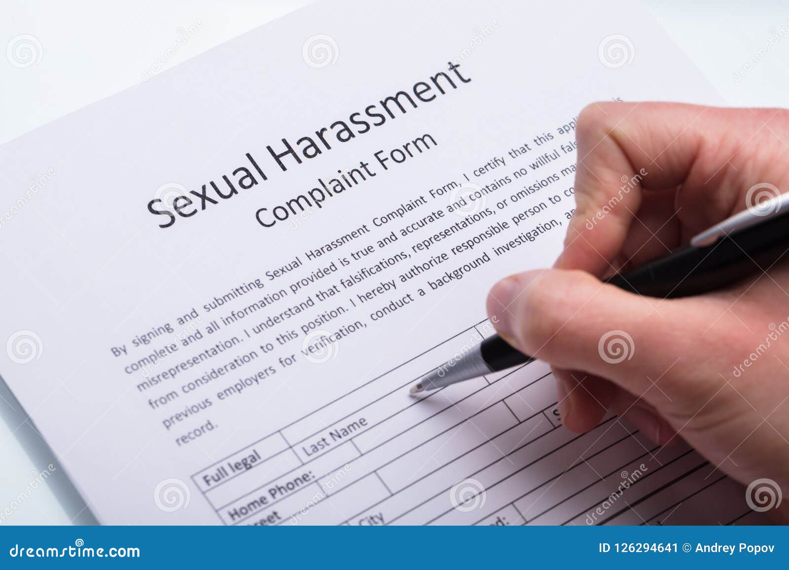 human hand filling sexual harassment complaint form