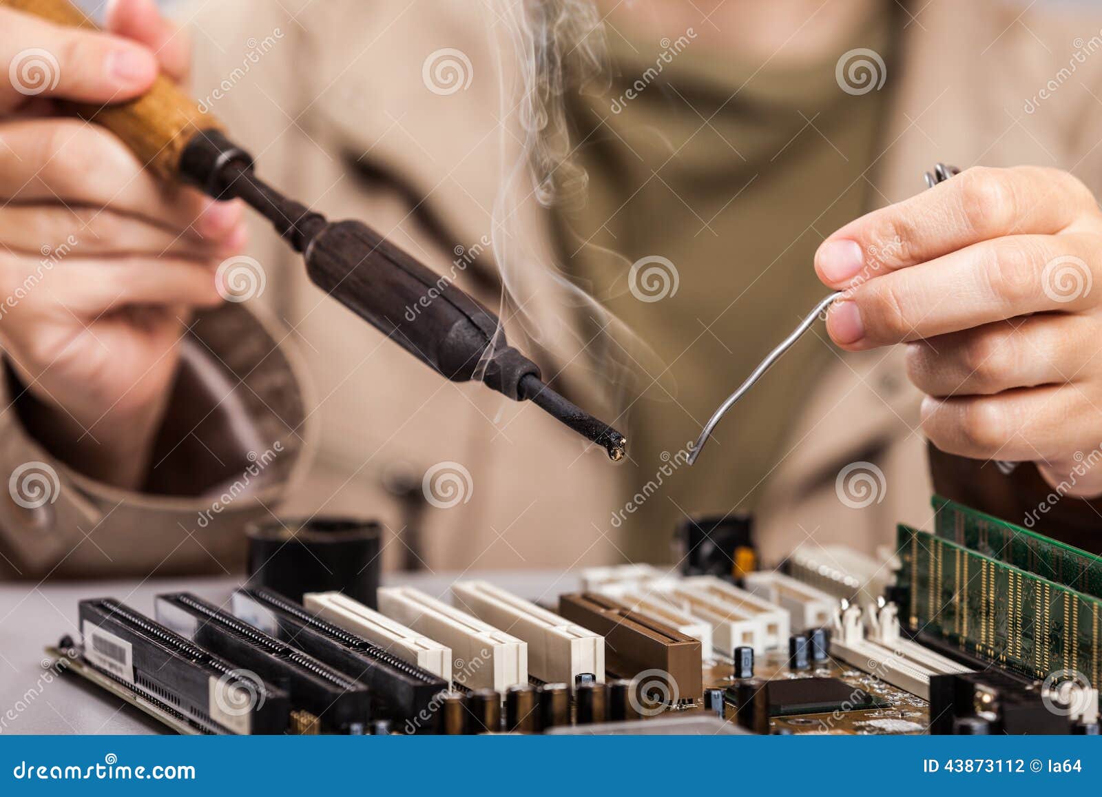 human hand holding soldering iron repairing computer boad