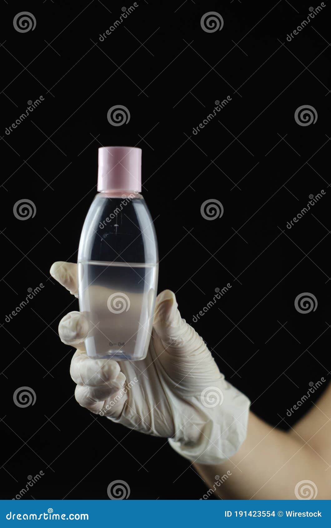 Human Hand with Rubber Glove Holding a Plastic Container of Hand