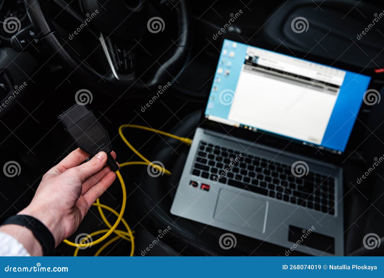 human making car diagnostics using obd device and computer.