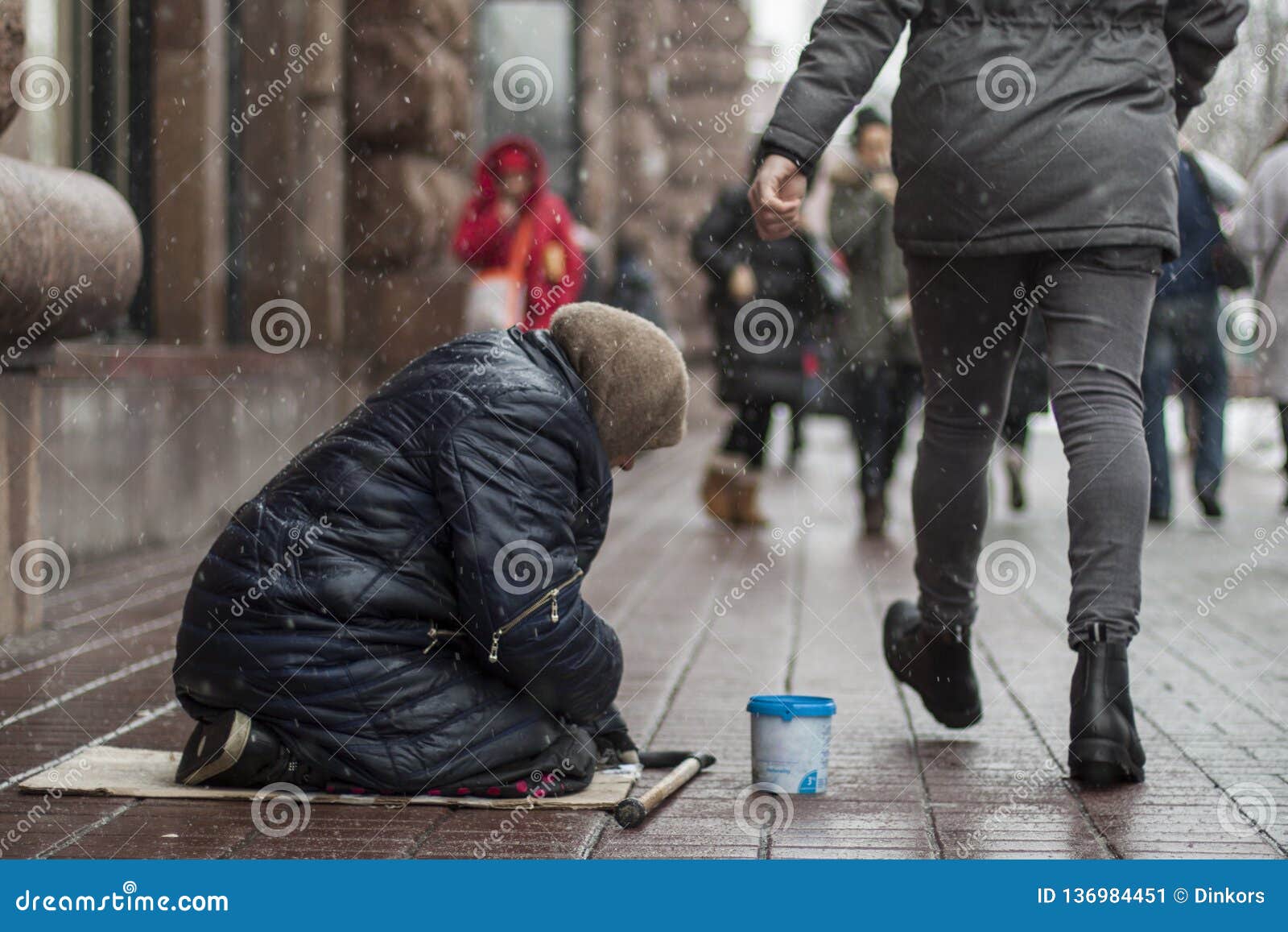 Hungry Homeless Beggar Woman Beg For Money On The Urban Street In The City From People Walking 