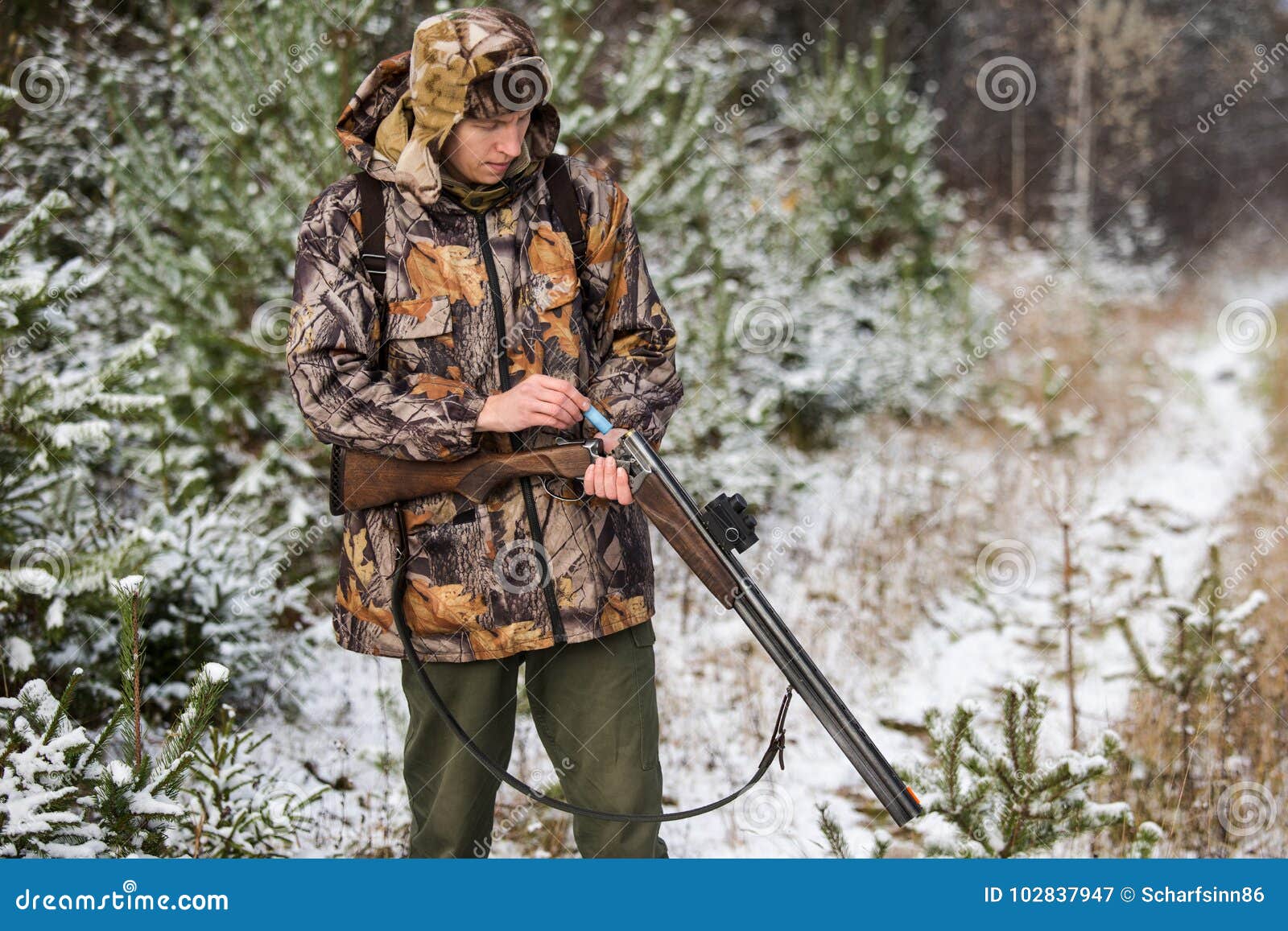 Hunter with a Backpack and a Hunting Gun in the Winter Forest. Stock ...