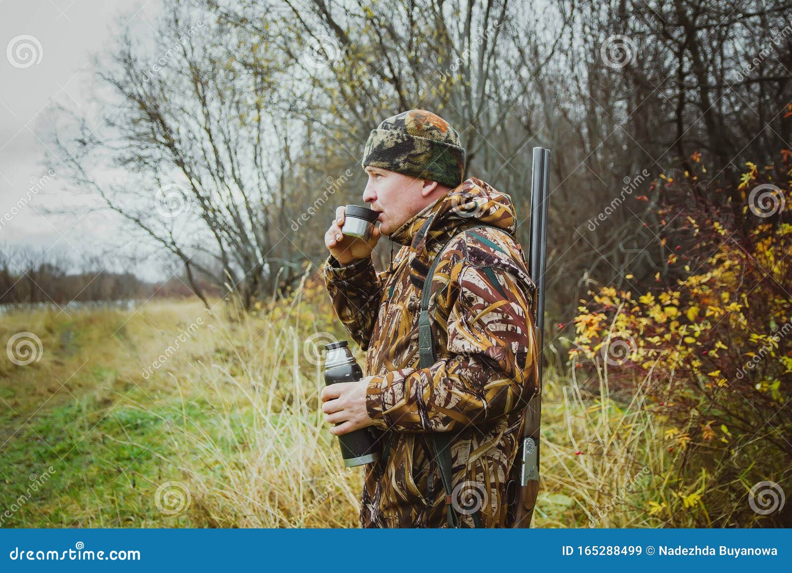 Hunter in Camouflage Clothing with a Gun in a Case Drinking Tea from a  Thermos Stock Image - Image of hand, equipment: 165288499