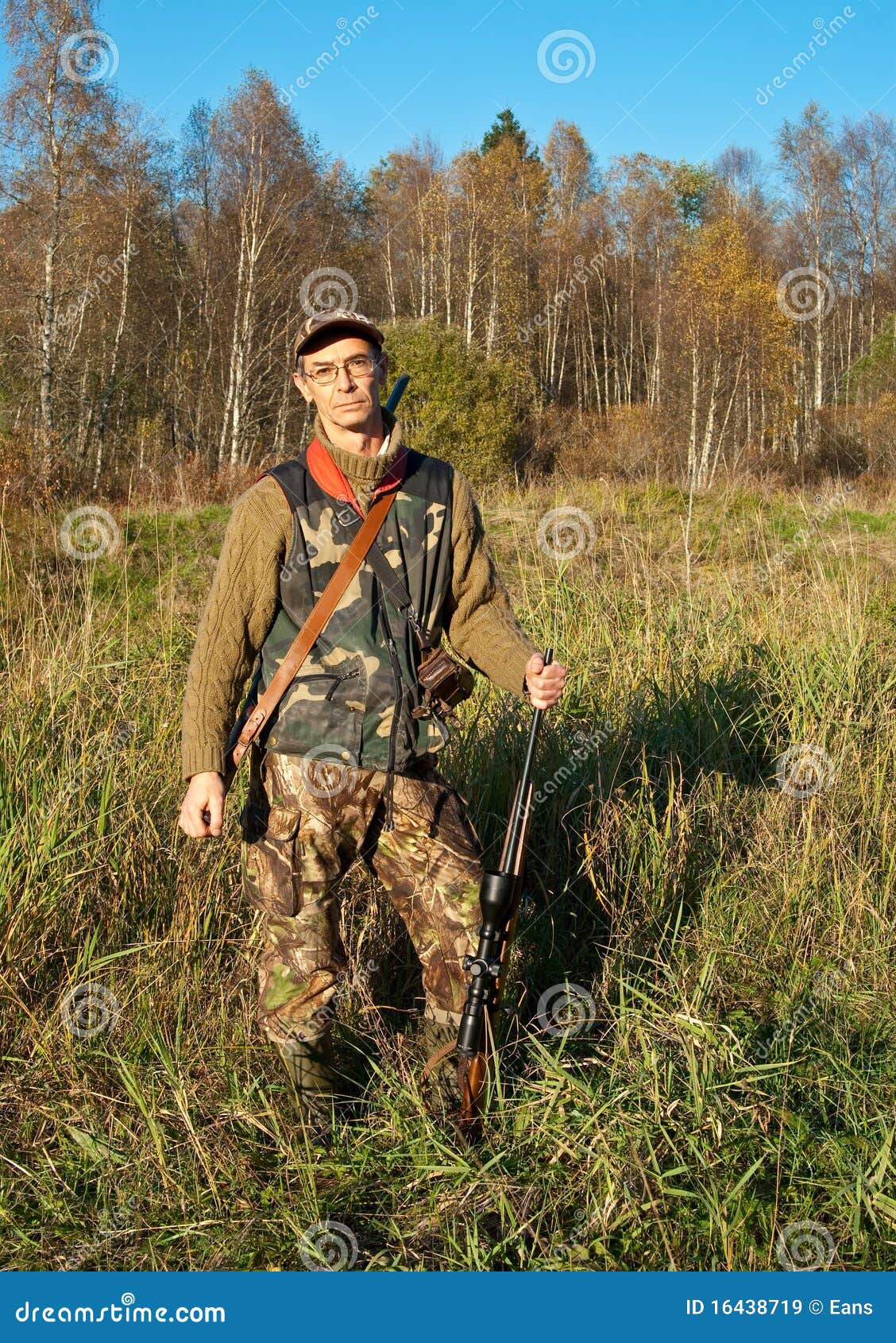 Hunter posing with rifle in nature