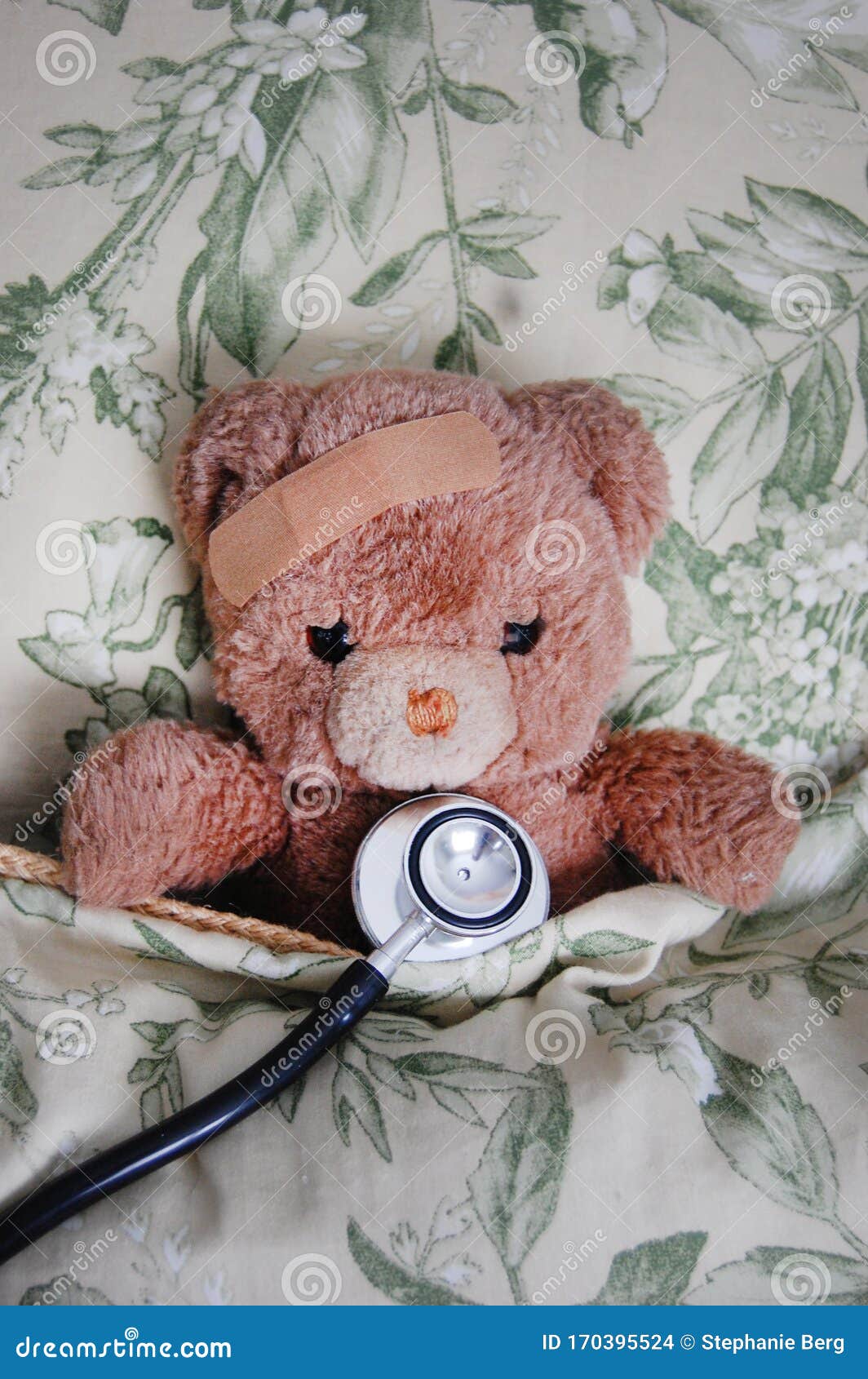 Hurt Teddy Bear in a Bed stock photo. Image of bandaid 170395524