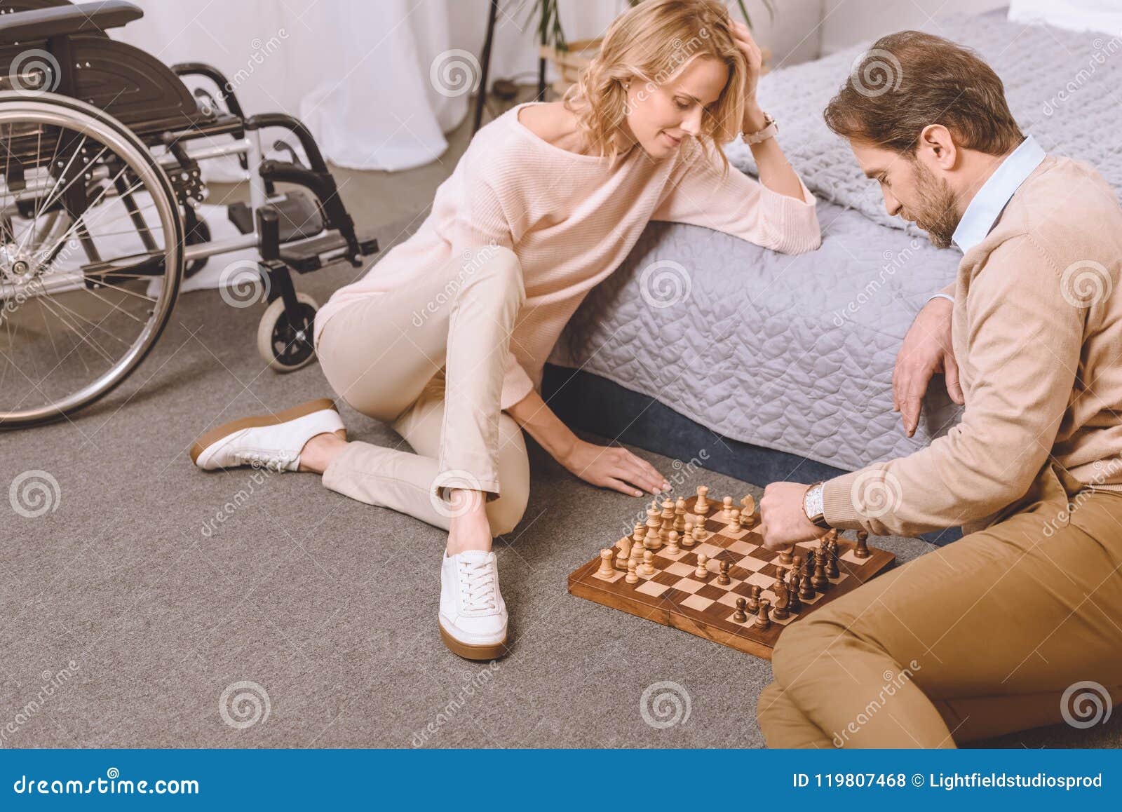 young couple playing chess while sitting at table at home - Unpacked