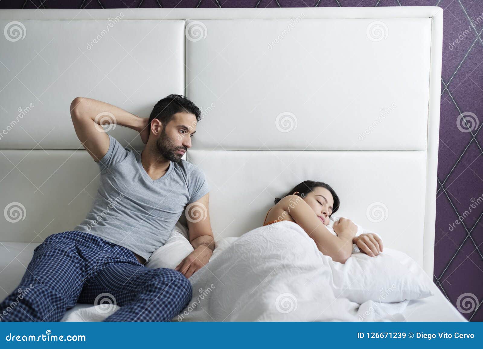 Man Trying Sexual Approach with Woman in Home Bed Stock Image