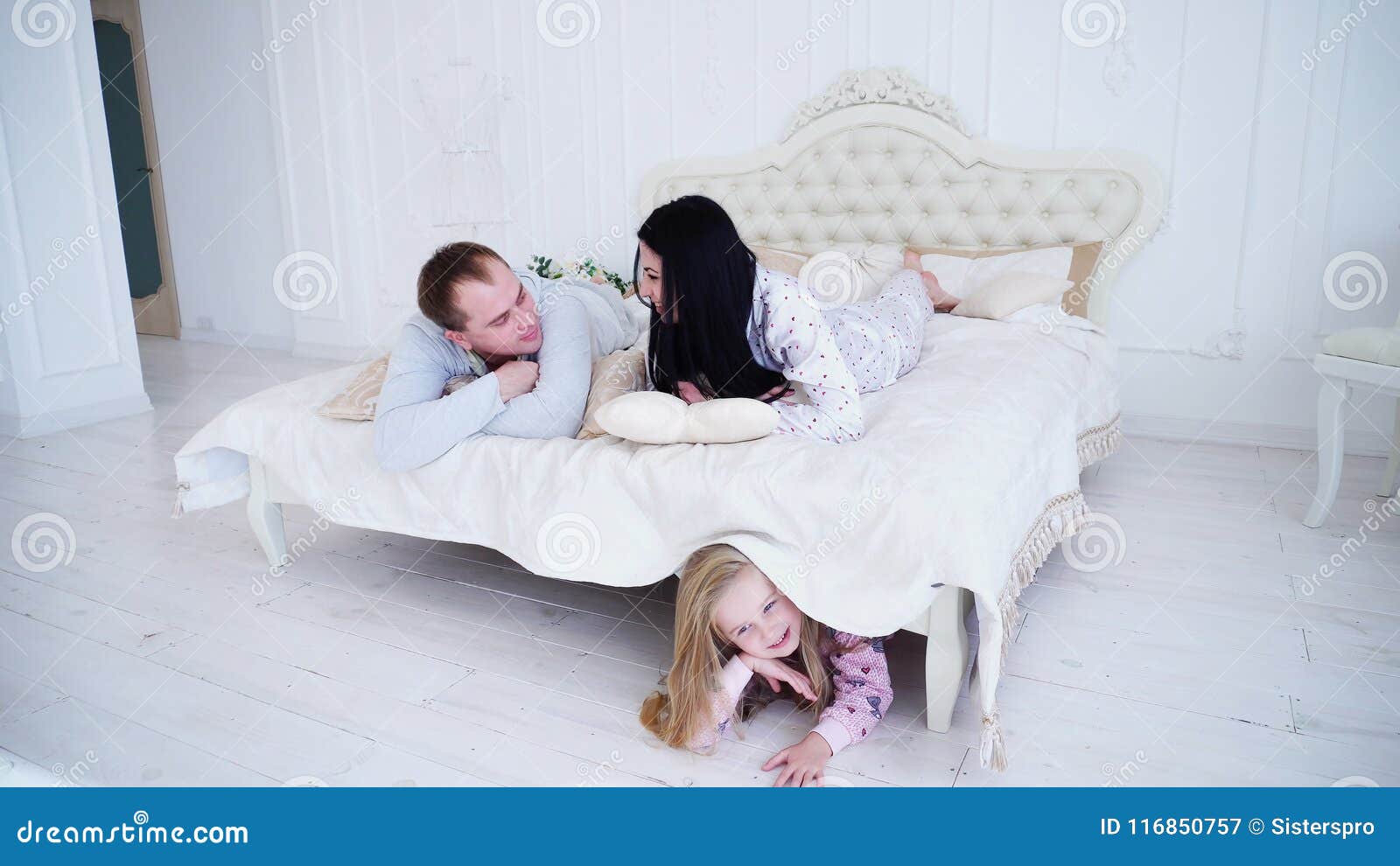 Husband And Wife Lying In Bedroom And Little Daughter Hiding Under Bed Stock Image Image Of Hiding Playful 116850757