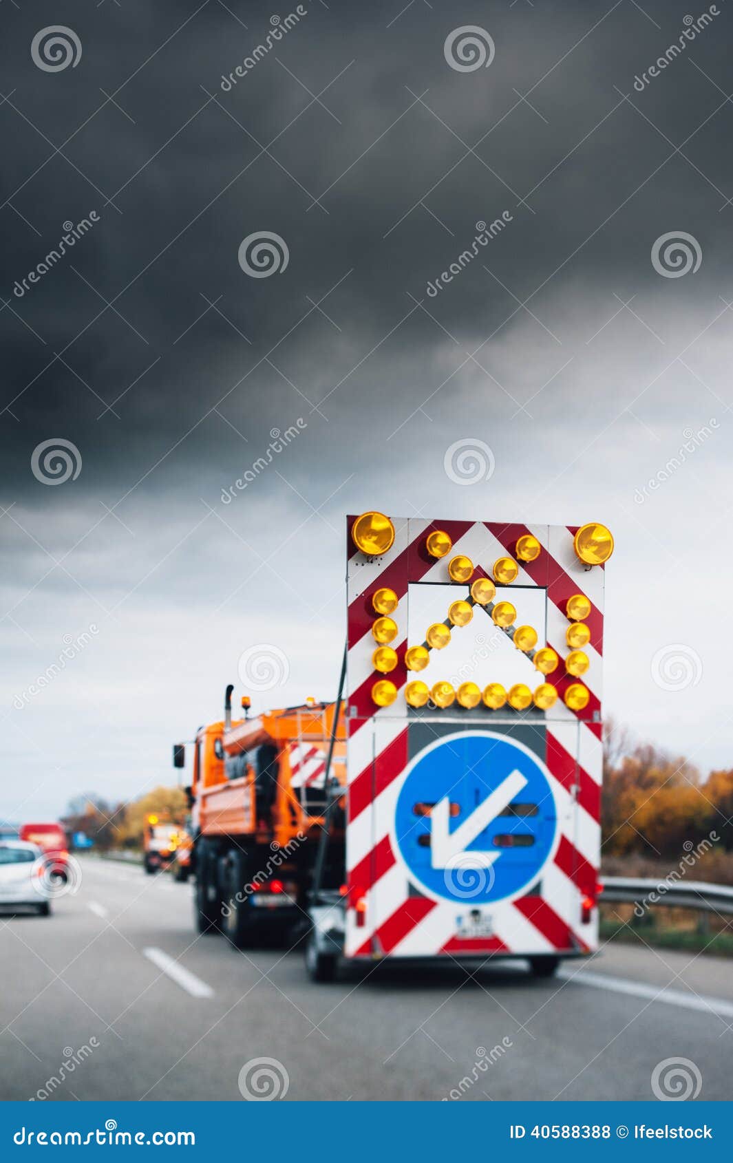 Huvudvägsäkerhetslastbil med säkerhetstecken- och säkerhetsljus på på autobahnen