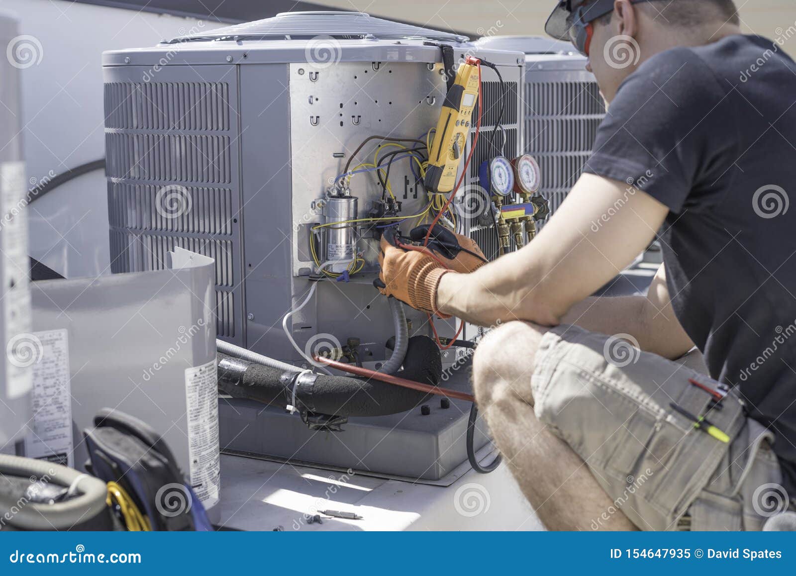 hvac technician working on controls of air conditioner