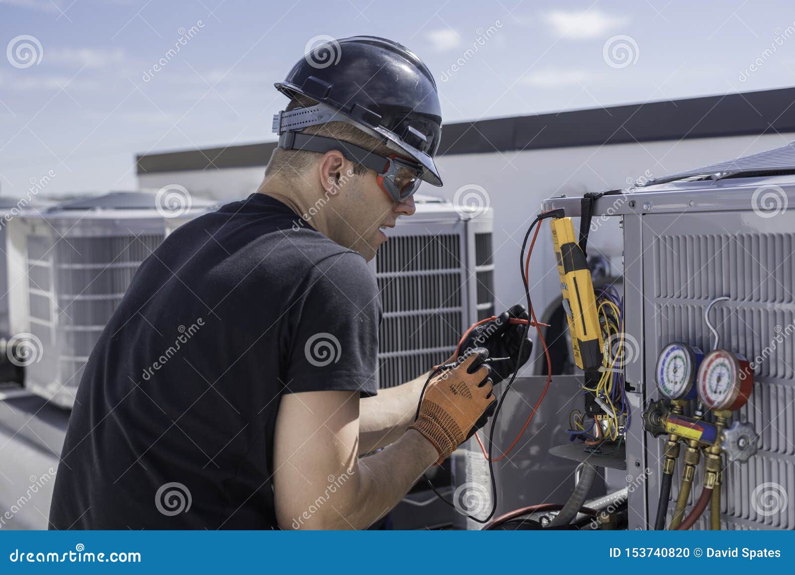 hvac tech repairing a condensing unit on roof