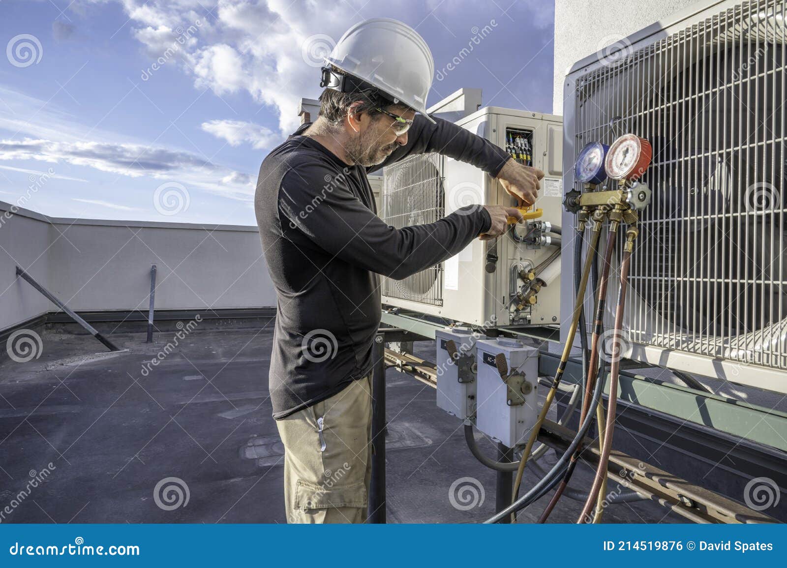 Hvac Tech Holding Gauges By Air Conditioner Condensers RoyaltyFree