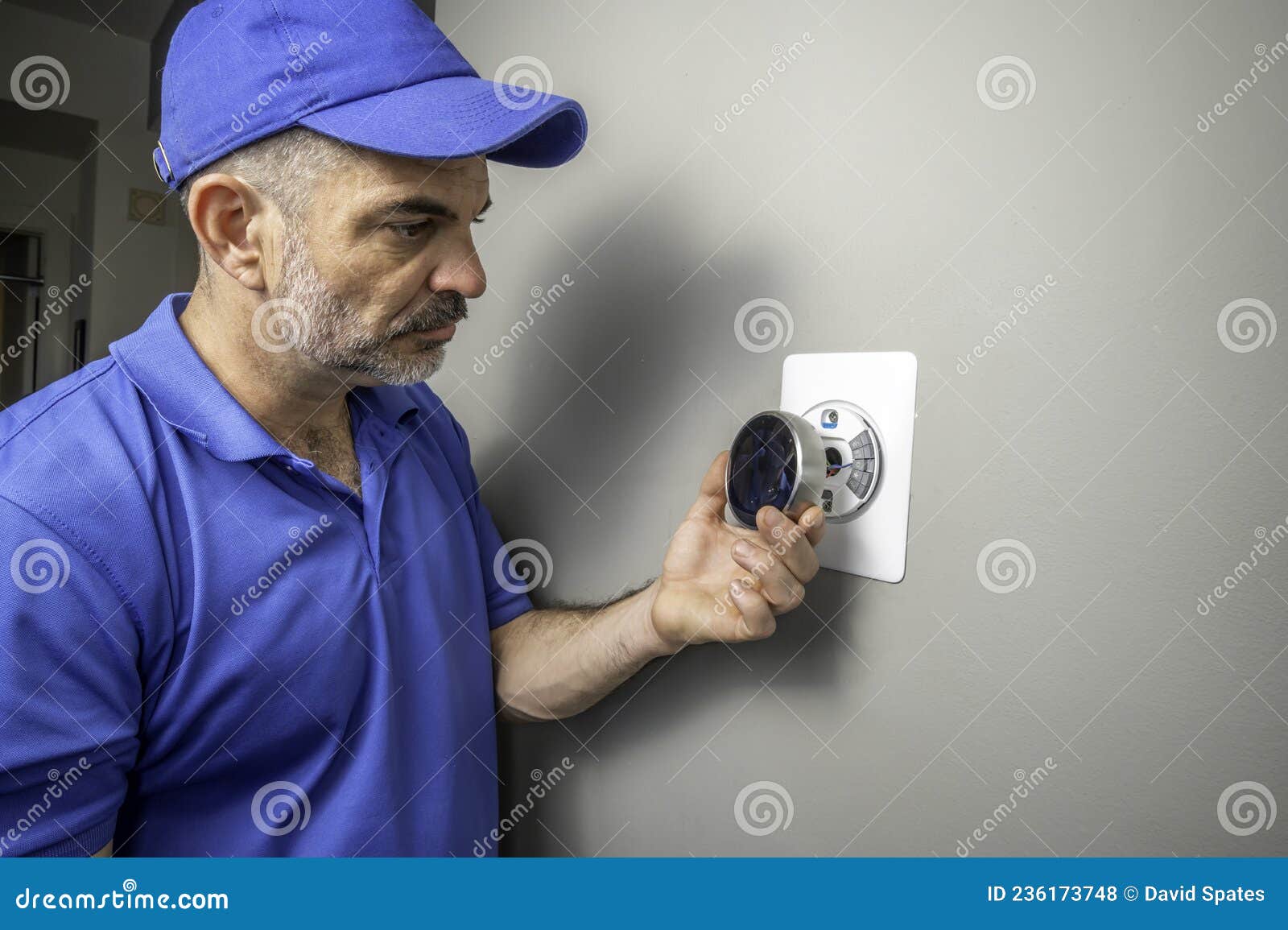 HVAC Technician Installing a Smart Thermostat Inside of a Home Stock