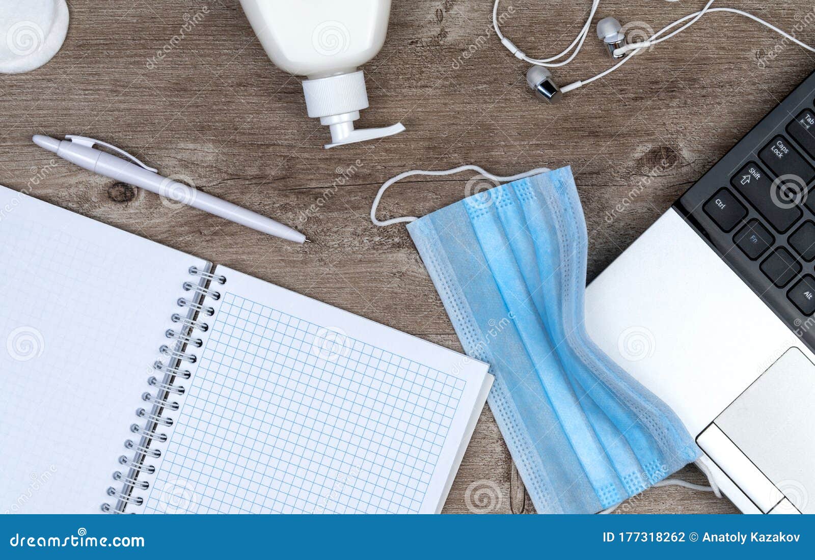 hygiene in the office. remote work kit on wooden desk. sanitizer gel and face mask