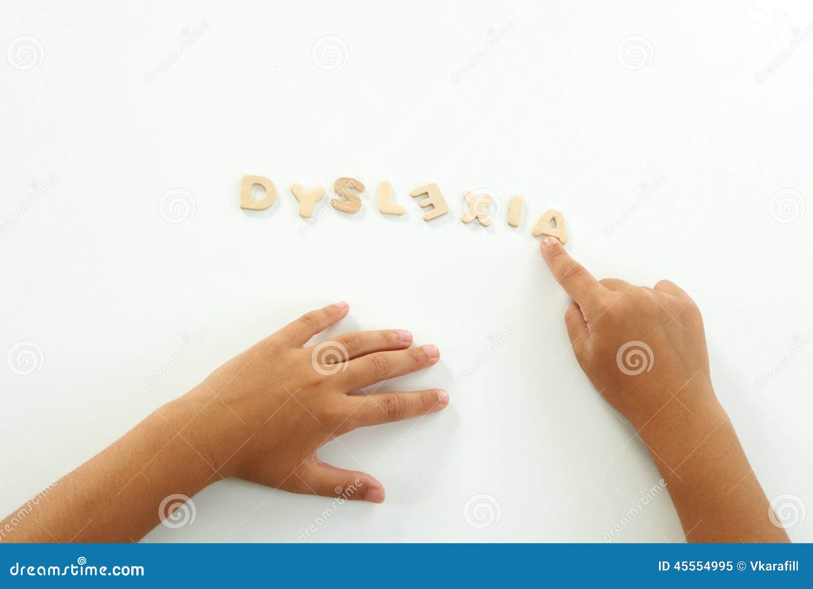 Hände eines Mädchens bilden die Wortdyslexie mit hölzernen Buchstaben
