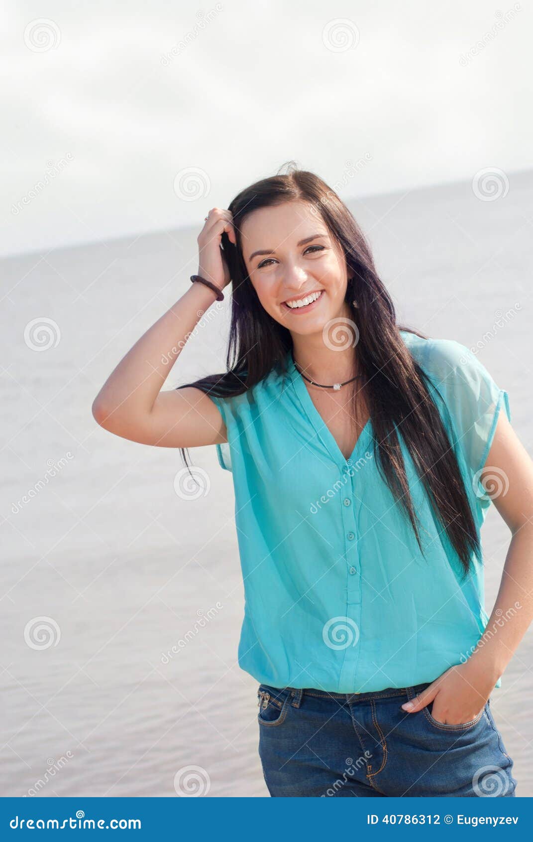 Härlig flicka som ler på havet på en solig dag