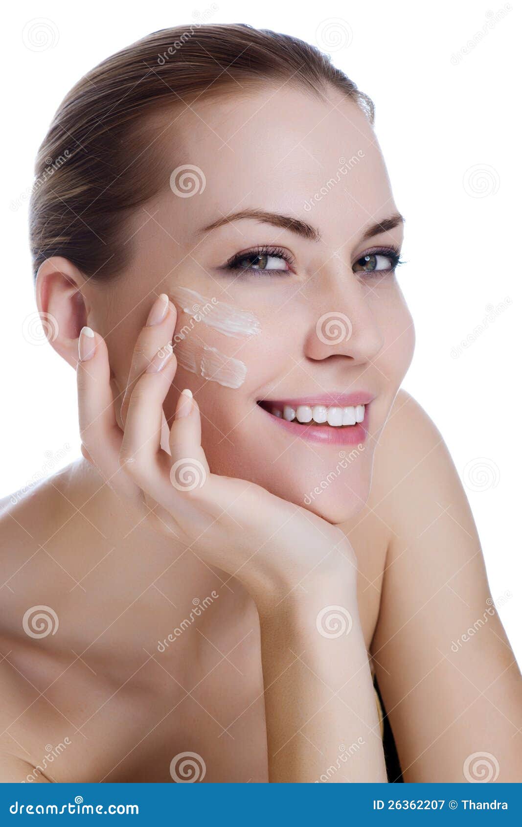 Lycklig le härlig kvinna som applicerar fuktighetsbevarande hudkrämkräm på framsidan