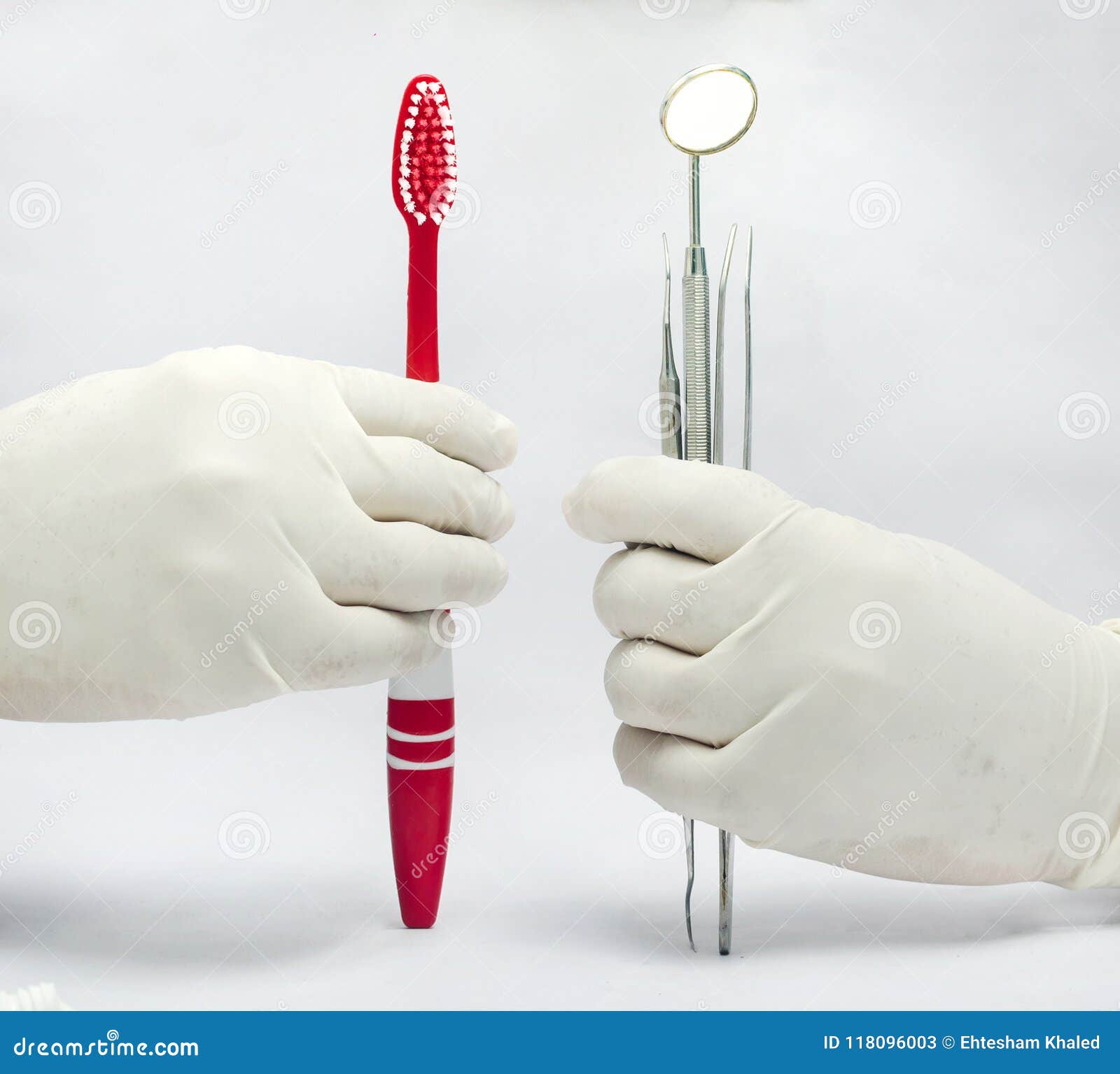Hållande tand- spegel- och sond- och tweezeramdtandborste som isoleras i vit bakgrund. Hållande tand- spegel och sond och pincett och tandborste som isoleras i vit bakgrund