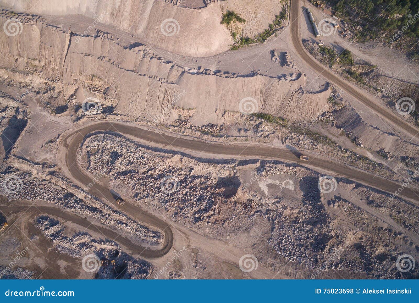 I camion industriali si muove lungo la strada nella cava della sabbia. La vista aerea del camion industriale si muove lungo la strada nella cava della sabbia 3 camion stanno muovendo nelle direzioni differenti lungo la carriera sabbiosa La Russia, 2106