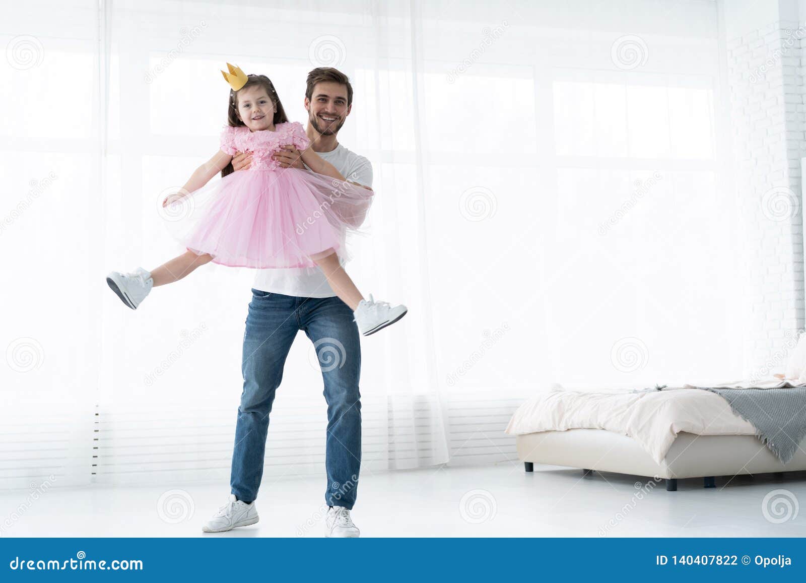 i love you, dad! handsome young man is dancing at home with his little girl. happy father`s day!