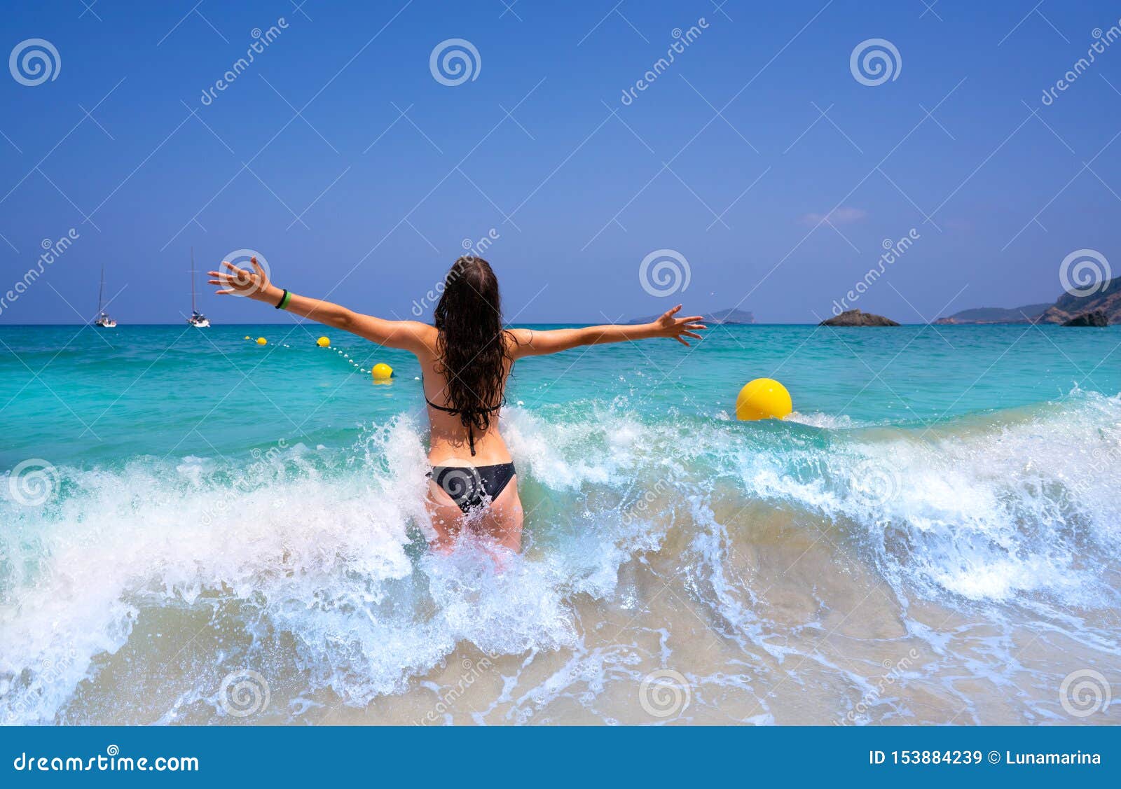 ibiza beach girl splashing water in balearics