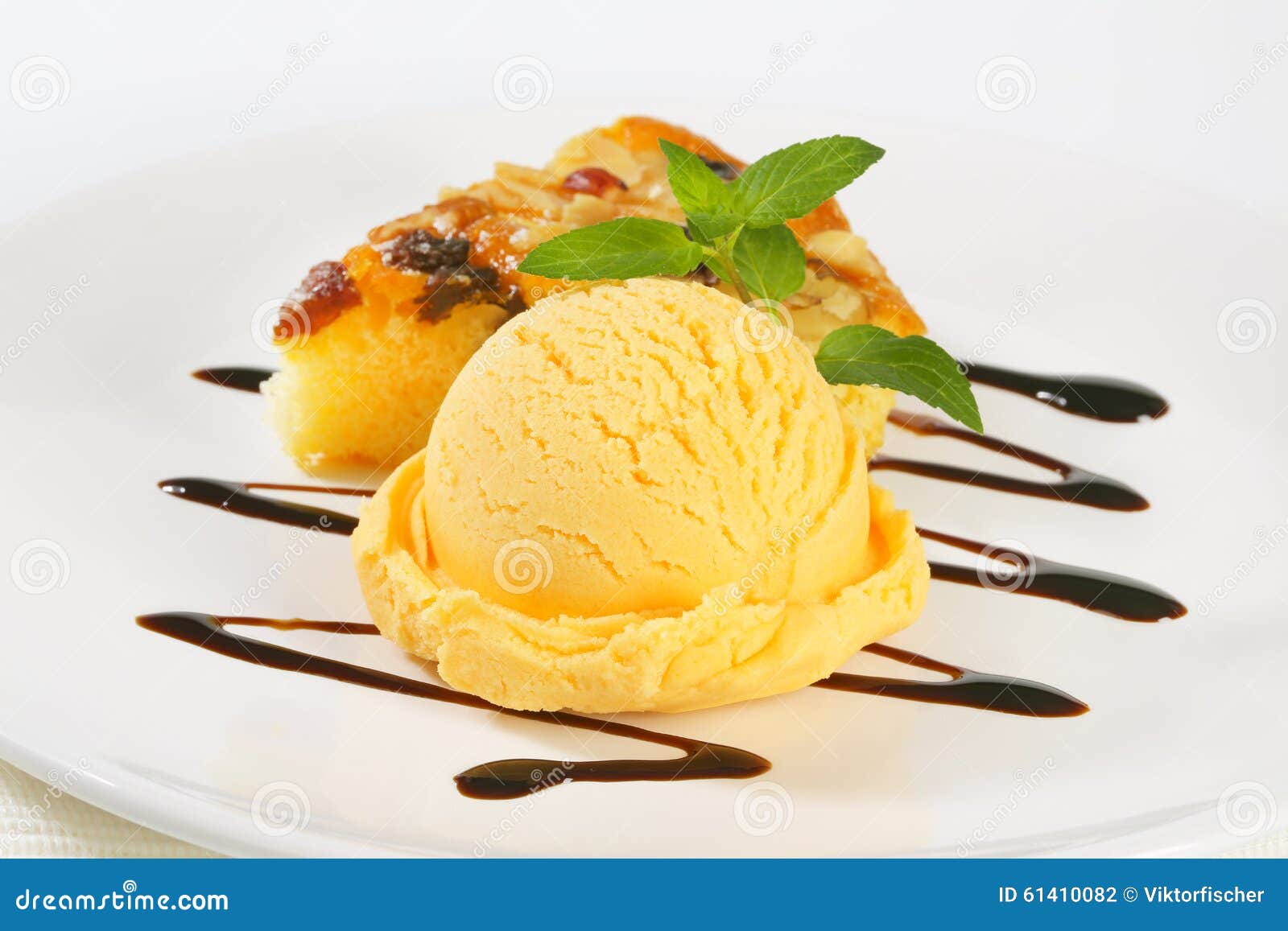 Ice cream and nut cake. Close up of scoop of yellow ice cream and slice of nut cake on white plate