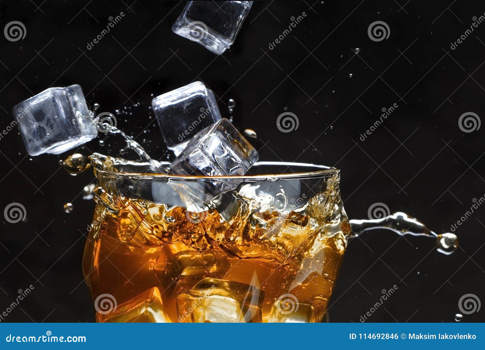 Ice Cubes Pour into a Glass with Alcohol. Splashes Stock Photo Image