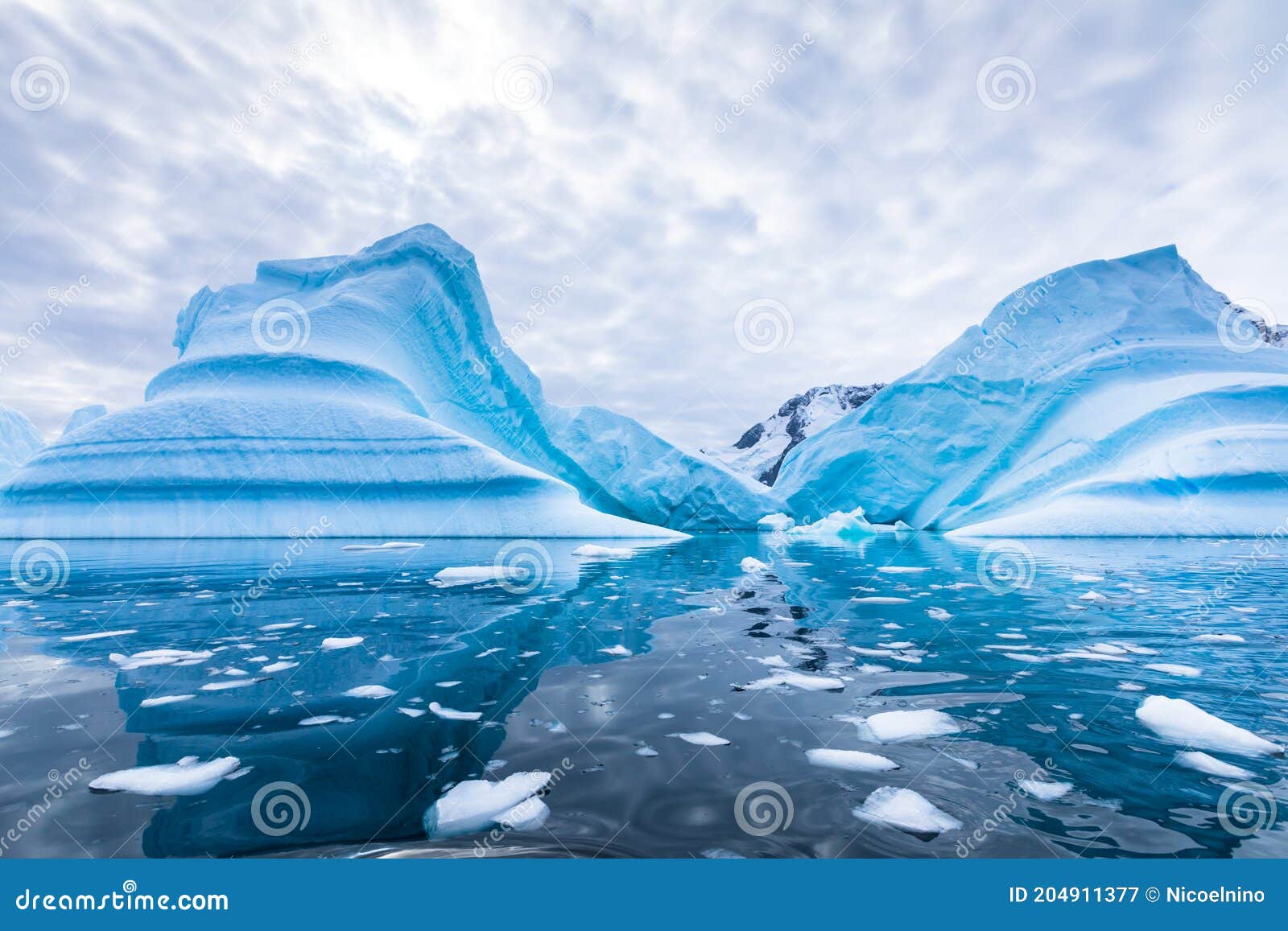 iceberg in antarctica floating in the sea, frozen landscape with massive pieces of ice reflecting on water surface, antarctic