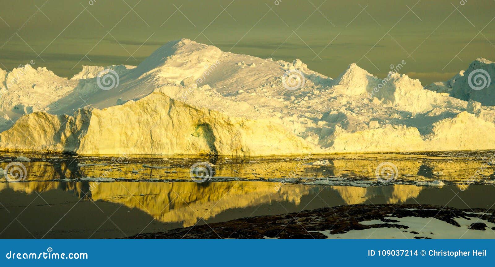 iceberg in greenland during sunset.