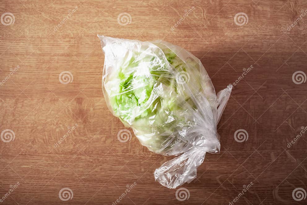 Iceberg Lettuce Vegetable in Plastic Bag. Single Use Plastic Packaging