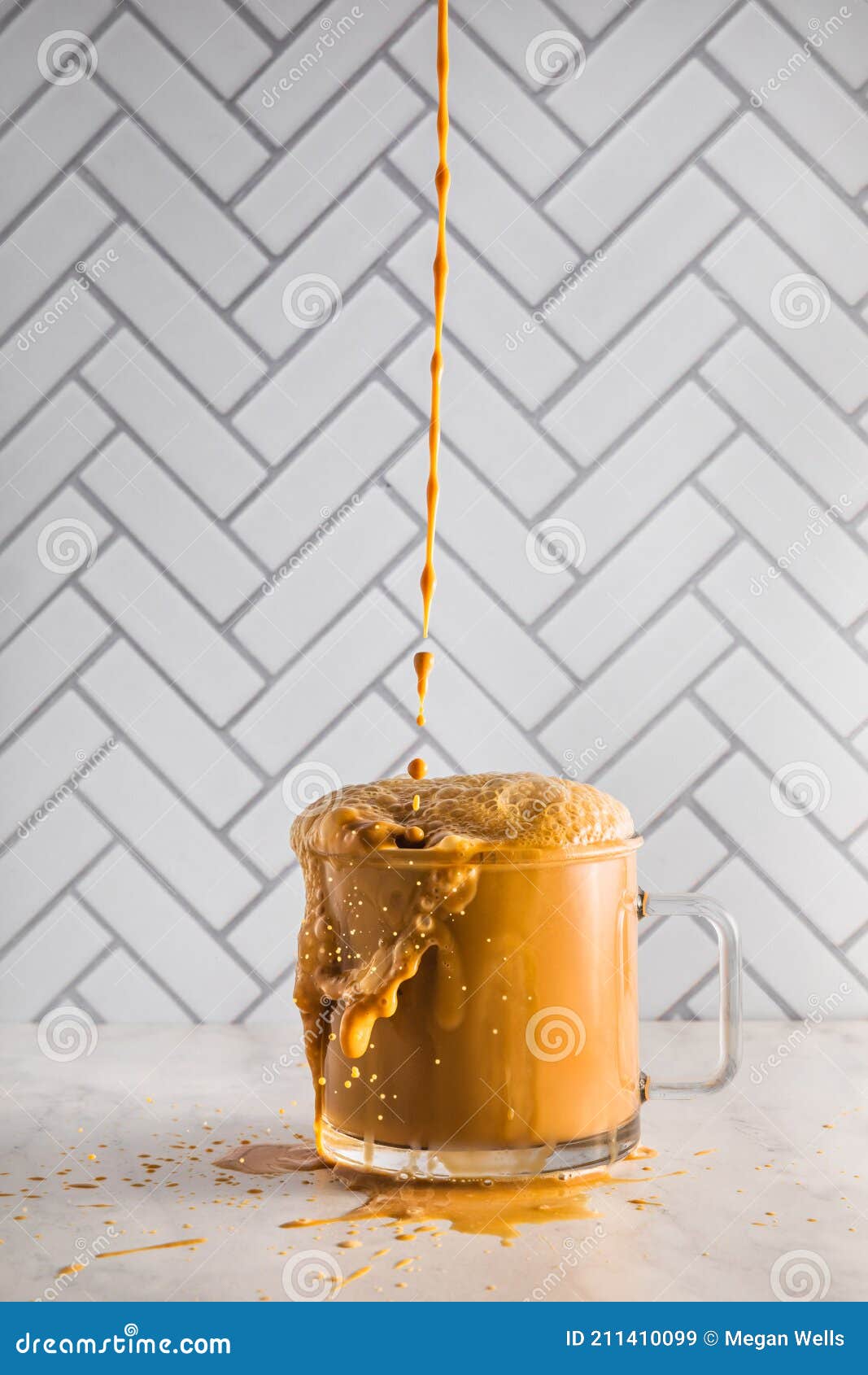 Iced Coffee Falling into an Overflowing Glass Coffee Mug Stock Image