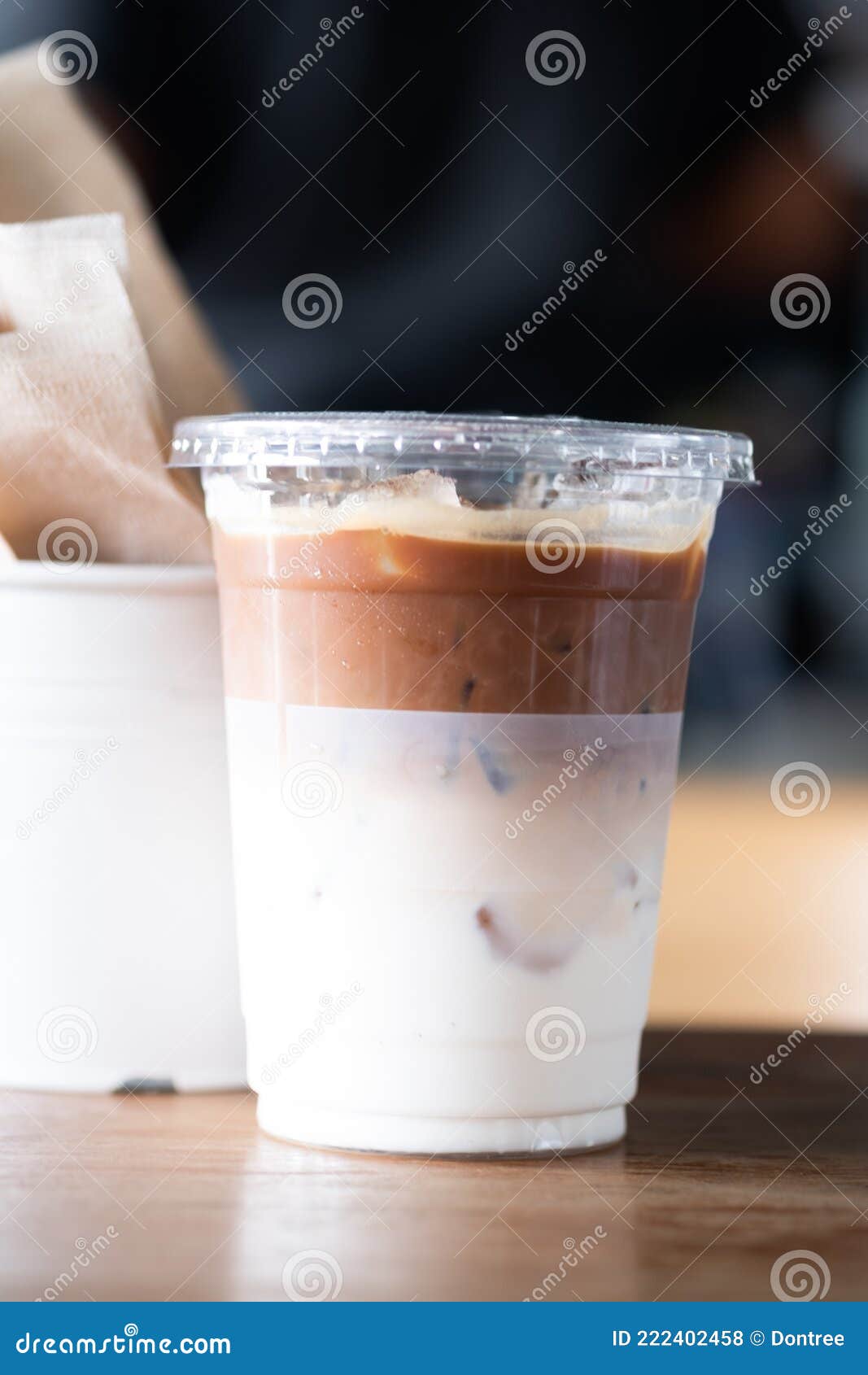 https://thumbs.dreamstime.com/z/iced-latte-coffee-bottom-as-milk-plastic-glass-oz-wood-table-222402458.jpg